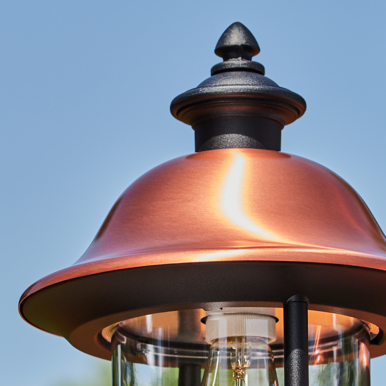 Nahaufnahme einer Außenlampe. Kupferschirm und Glühbirne sind sichtbar.