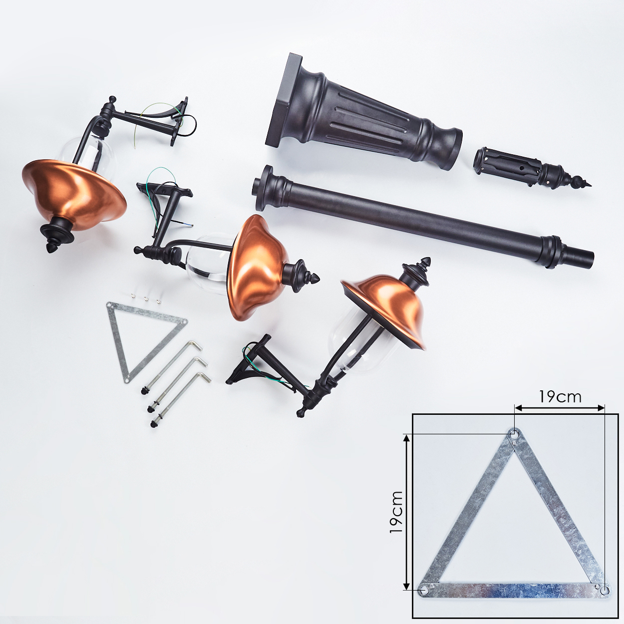 Zerlegte Teile einer Außenlampe mit Kupferschirmen und einem Dreieck. Weißer Hintergrund.