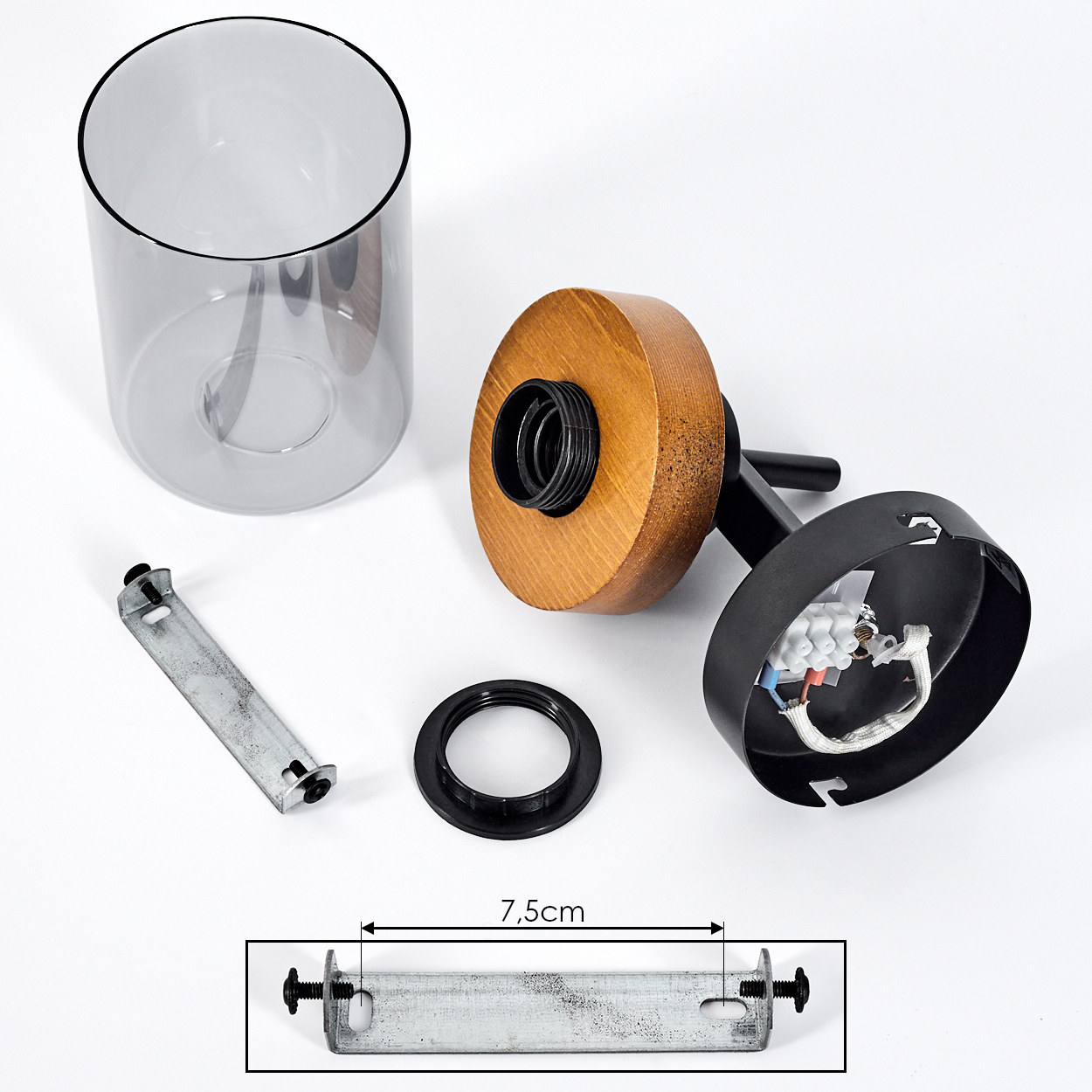 Komponenten einer Lampe: ein Glaszylinder, Holzsockel, Metallhalterung und schwarzer Ring. Vor weißem Hintergrund gezeigt.