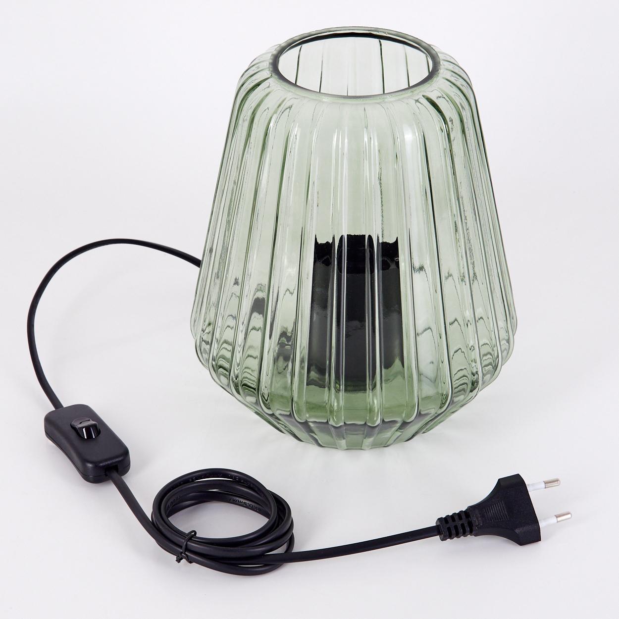 Eine grüne Glaslampe mit sichtbaren vertikalen Linien. Sie hat ein schwarzes Kabel und einen Stecker.