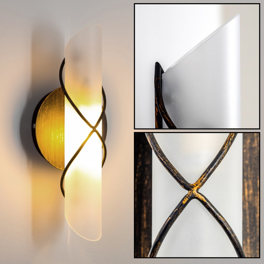 Eine Wandlampe mit Milchglasschirm und goldenen Akzenten, an einer weißen Wand befestigt.