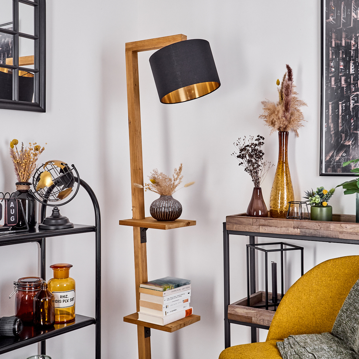 Holz-Stehleuchte mit Regalen, schwarzem Lampenschirm und Dekorationsgegenständen. Hintergrund: weiße Wand und Deko.