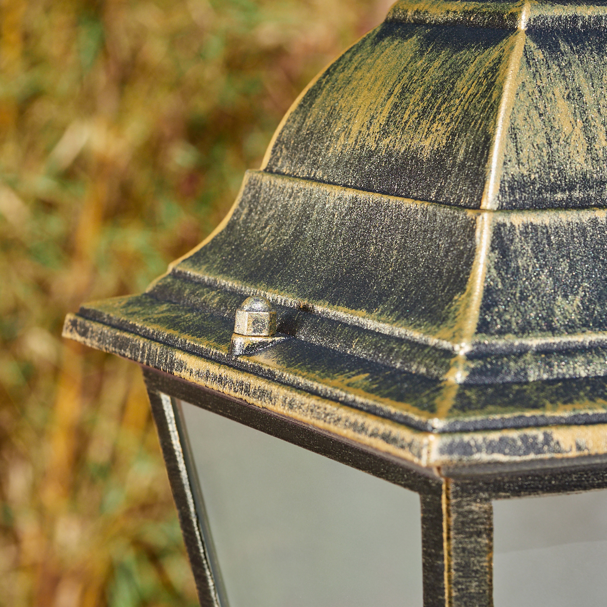 Nahaufnahme des oberen Teils einer Lampe. Schwarz und Gold, strukturierte Oberfläche.