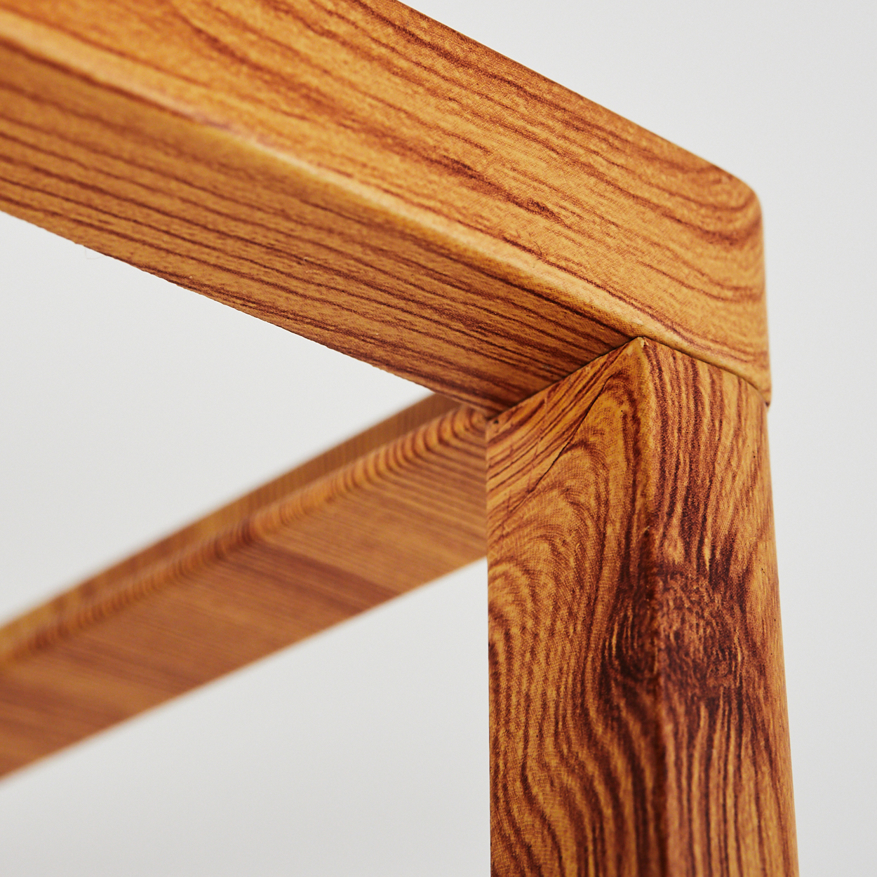Nahaufnahme einer Ecke einer Holzlampe, die die Holzmaserung und die Verbindungsdetails zeigt.