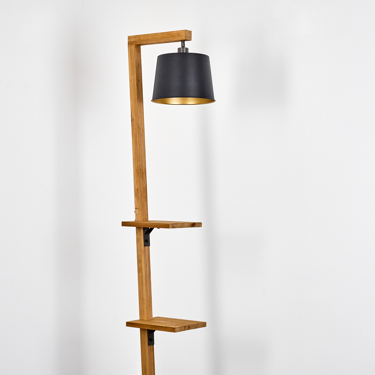 Holz-Stehlampe mit Regalen und schwarzem Lampenschirm. Weißer Hintergrund.