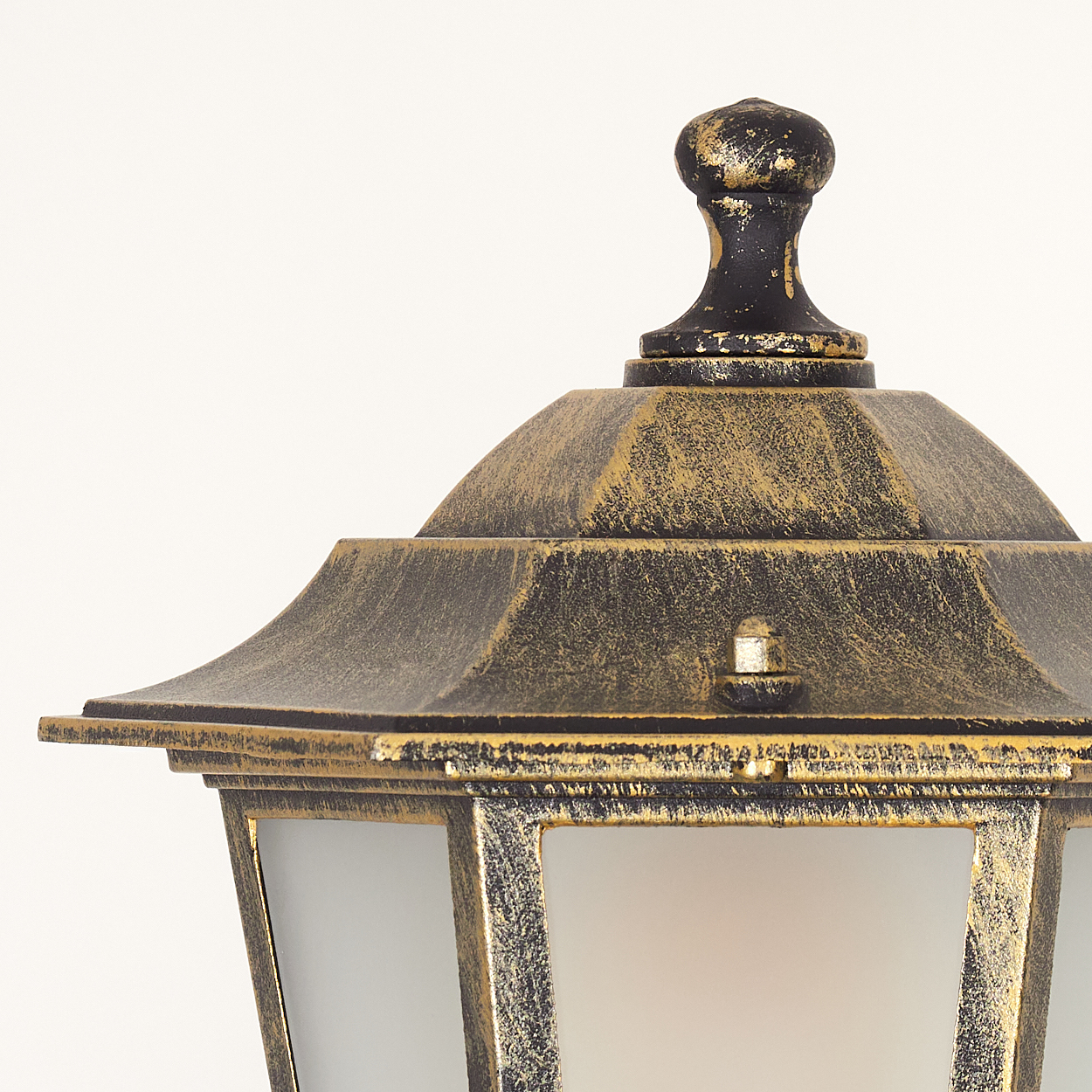 Nahaufnahme eines Laternenpfahls mit Gold-Schwarz-Finish. Weißer Hintergrund.