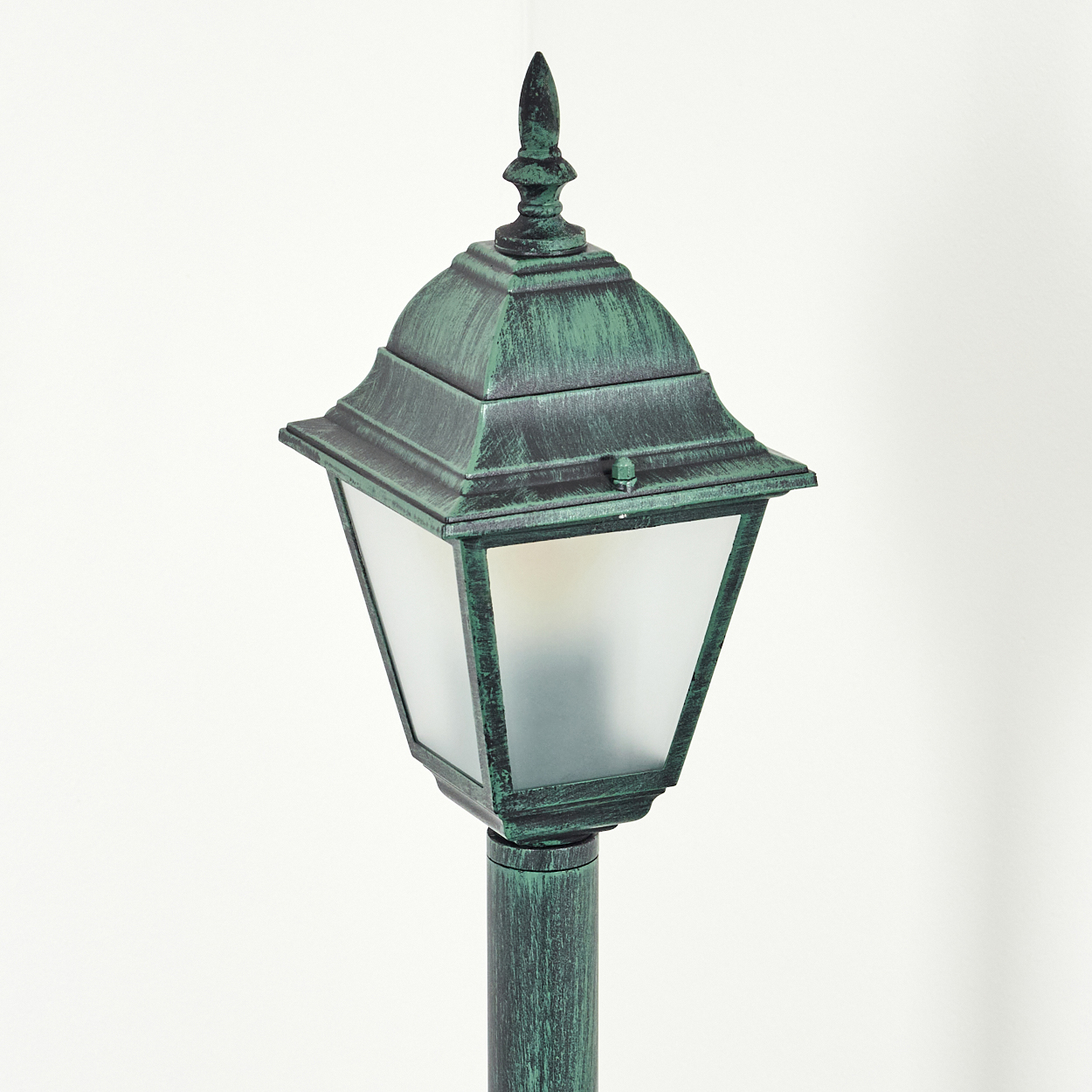 Ein grüner Außenlampenpfosten, ein klassisches Design mit einer mattierten Glasscheibe.