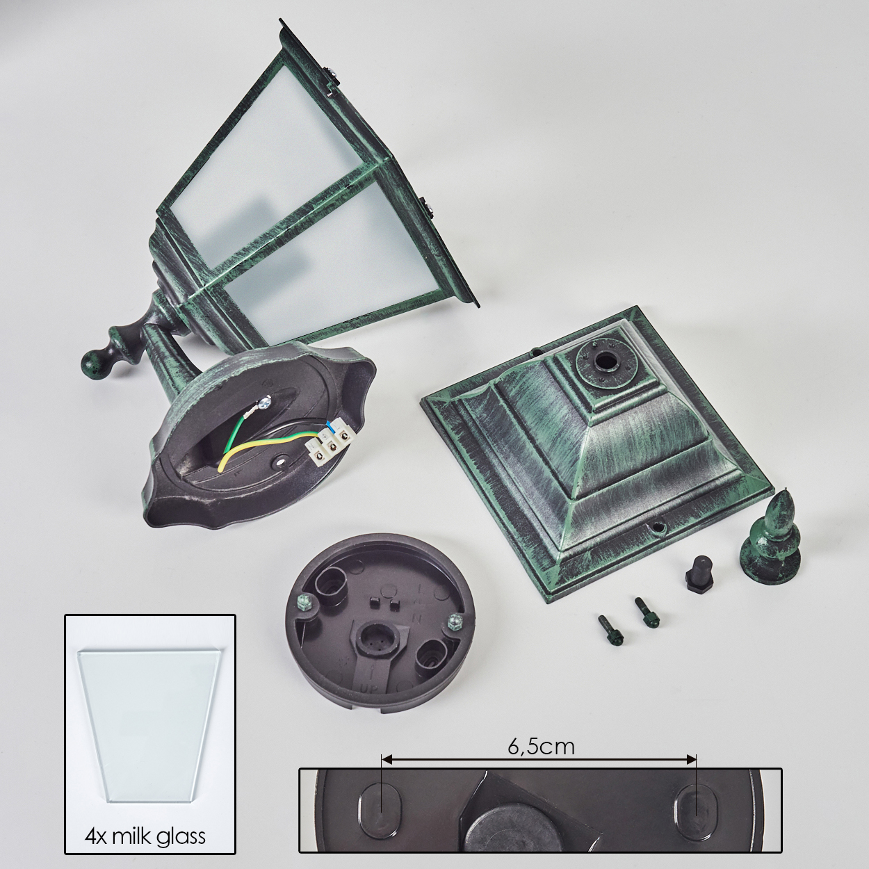 Zerlegte grüne Lampenteile: Sockel, Oberteil, Glas, Schrauben und ein kleiner Sockel.