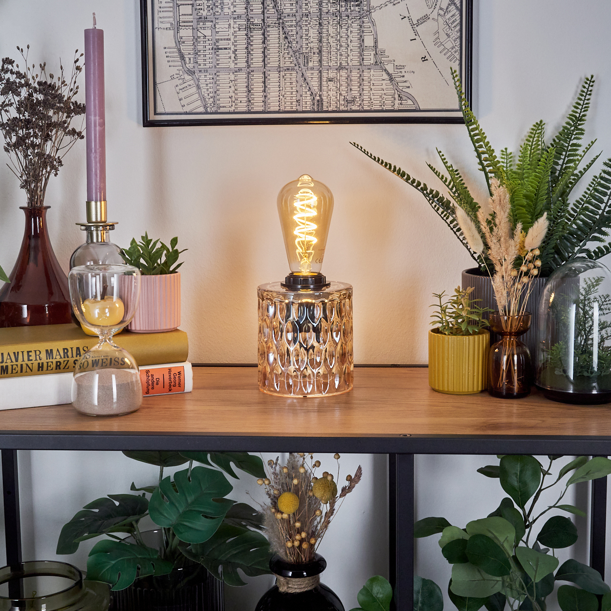 Tischlampe mit strukturierter Glasbasis und Glühbirne im Vintage-Stil auf einem Holzregal.