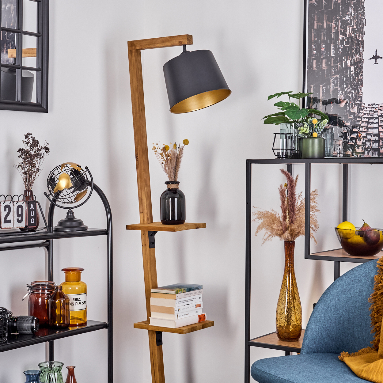 Eine Holz-Stehlampe mit schwarzem Lampenschirm und Regalen. Der Raum hat andere Dekorationsgegenstände.