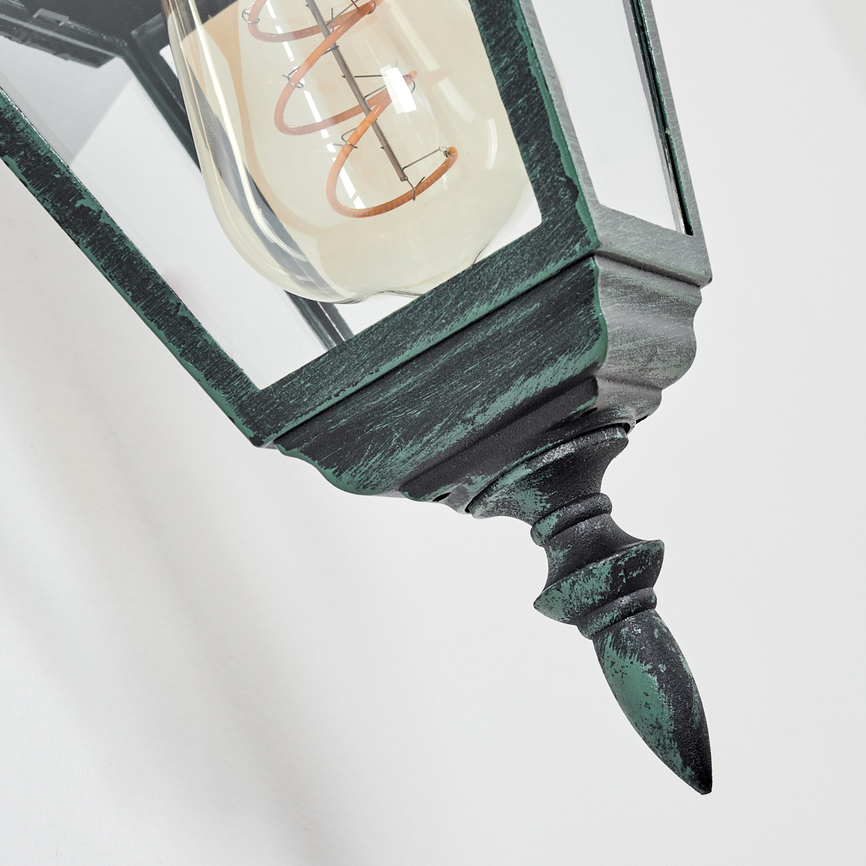 Nahaufnahme des grünen Wandlampenfußes. Zeigt die Unterseite der Lampe.