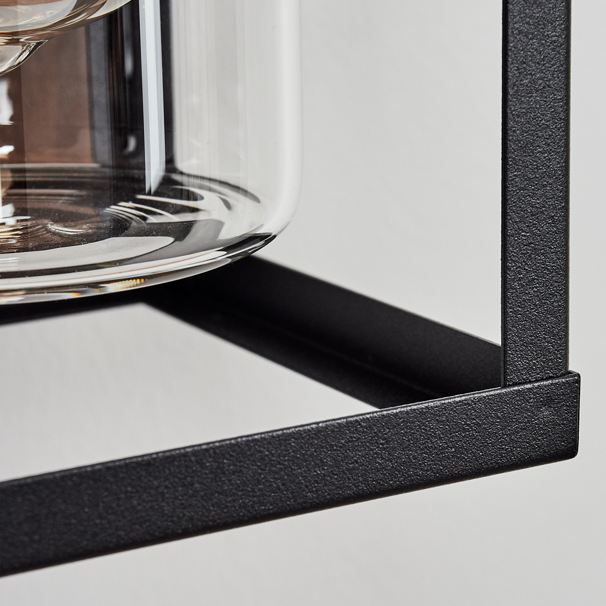 Nahaufnahme eines schwarzen Lampengestells mit einem Glaszylinder. Weißer Hintergrund. Teil einer Lampe.