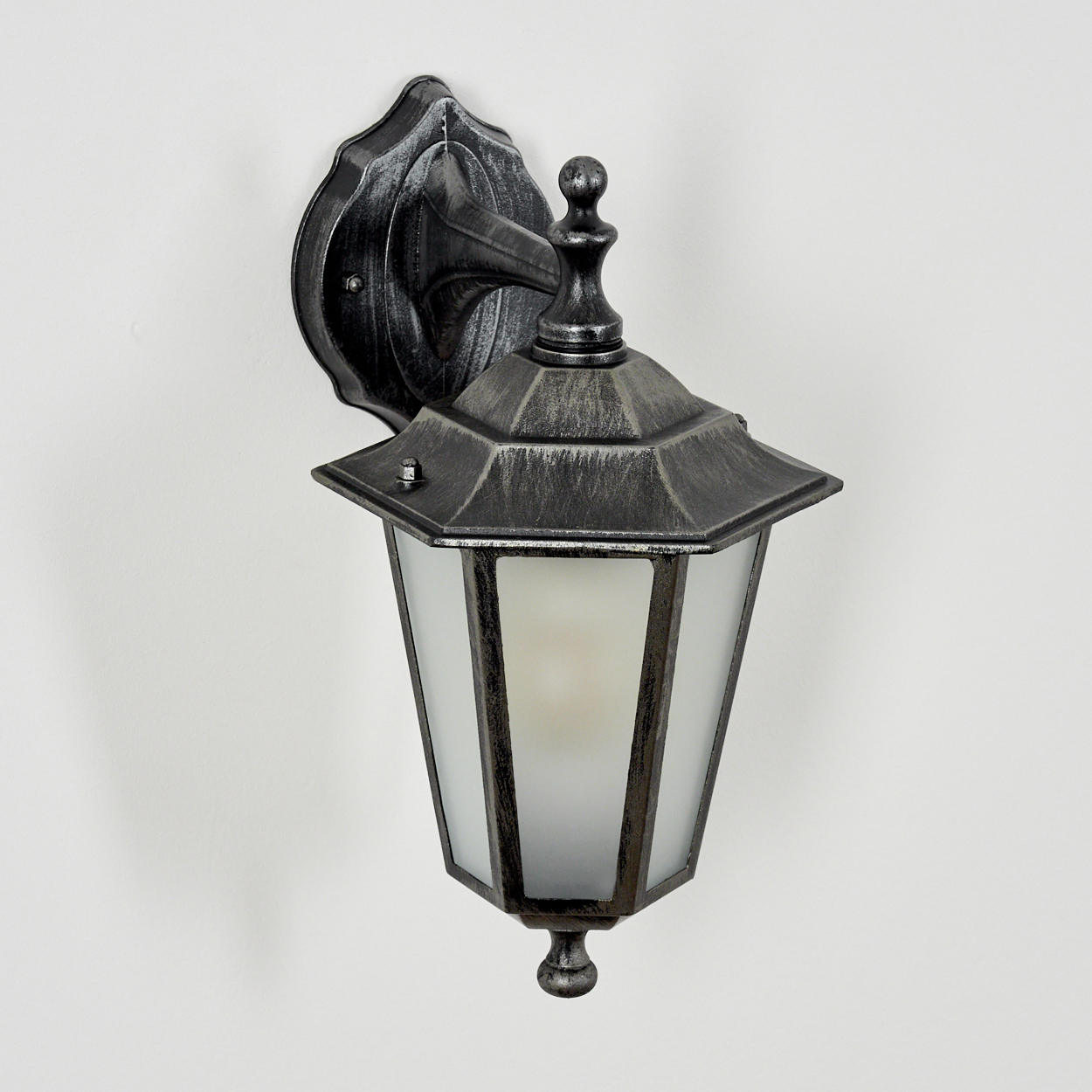 Eine silber-schwarze Wandlampe mit einer mattierten Glühbirne. Weißer Hintergrund.