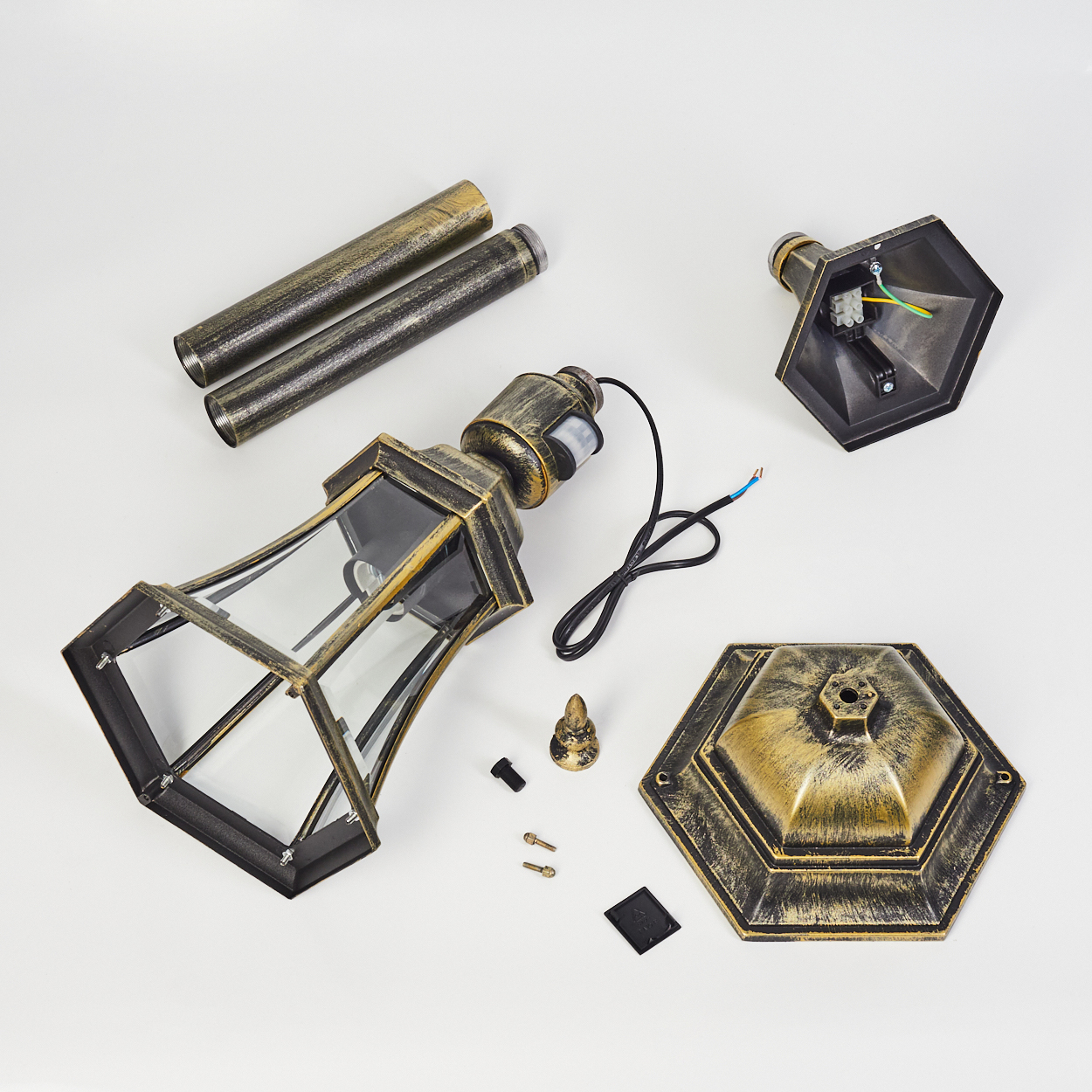 Zerlegte Komponenten eines goldenen Außenlampenpfostens: Glasgehäuse, Sockel, Lampe und andere Teile. Weißer Hintergrund.