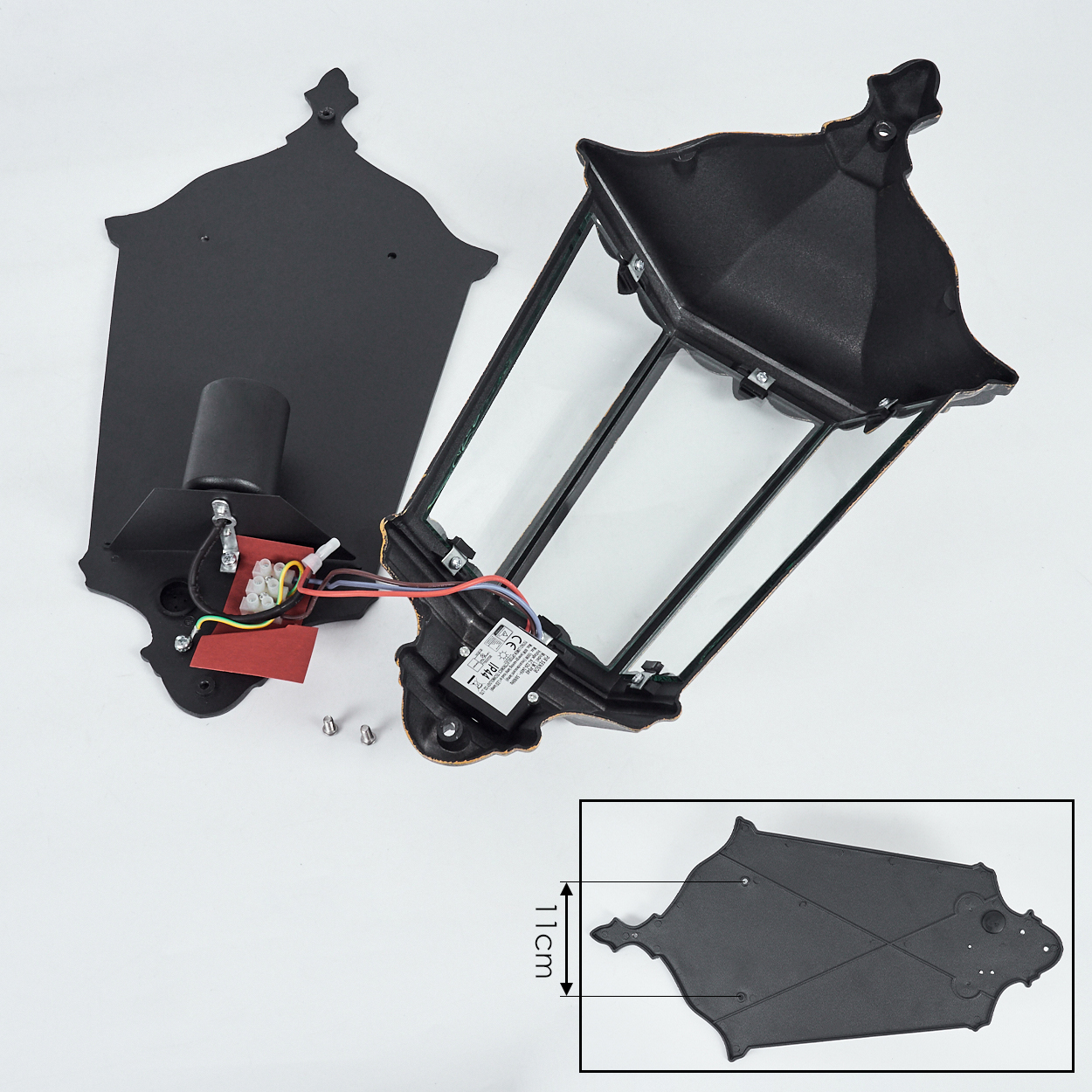 Zerlegte schwarze Wandlampe mit Komponenten auf weißer Oberfläche. Enthält die Lampenteile.