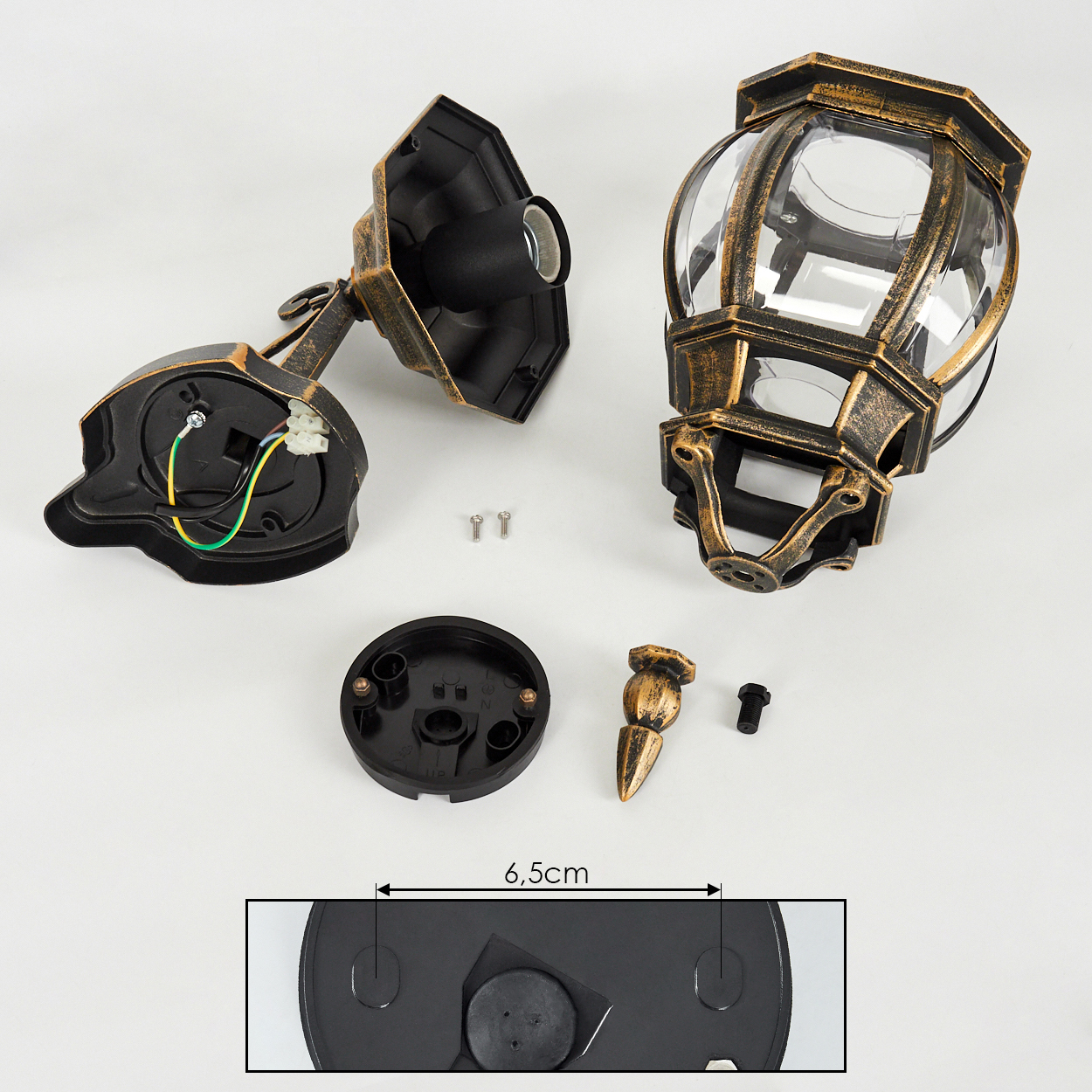 Zerlegte goldene Metall-Wandleuchte. Schrauben und andere Teile sind zu sehen.