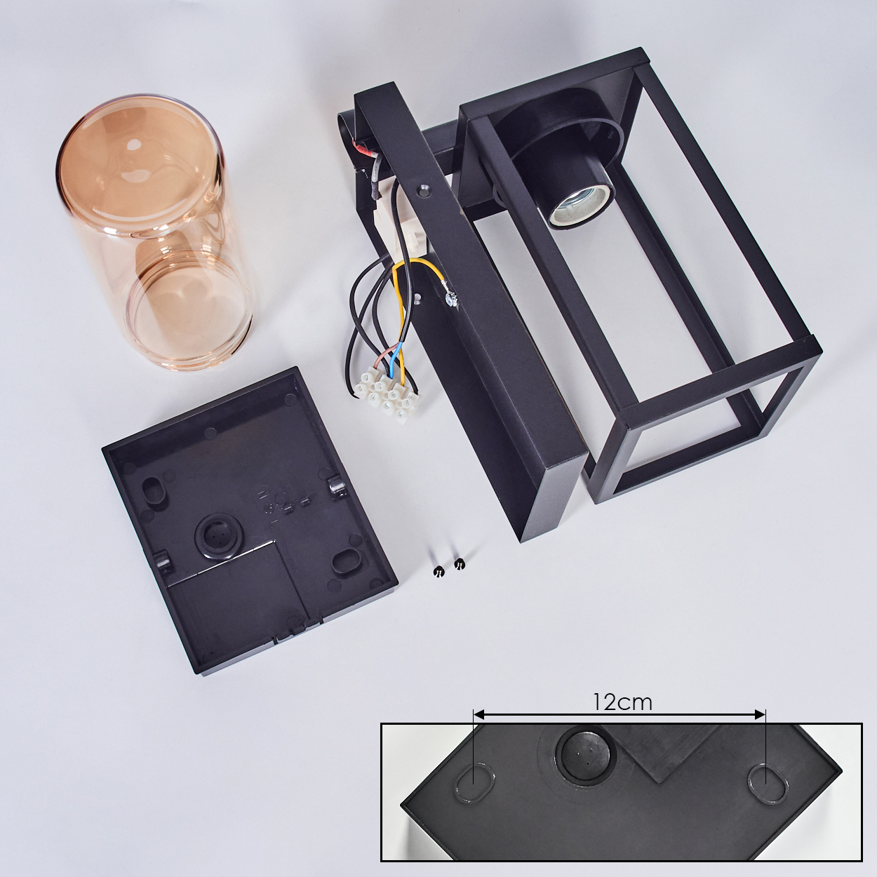 Zerlegte schwarze Außenlampe mit einem Zylinder aus klarem Glas. Die Basis ist schwarz.