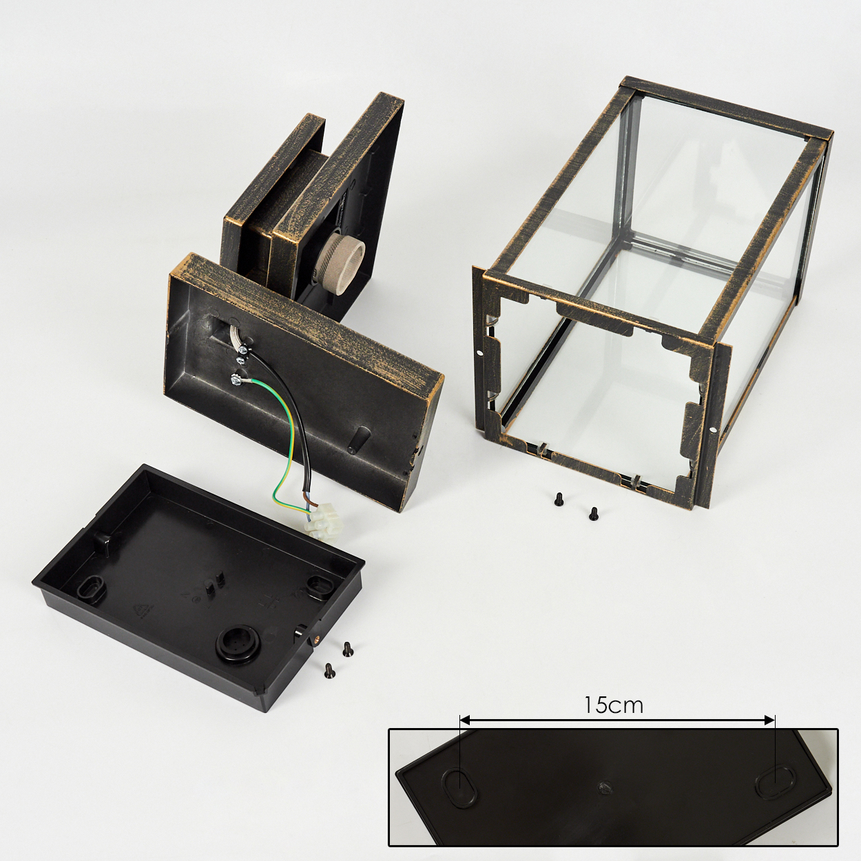 Zerlegte schwarze und goldene Außenlampe. Teile umfassen die Basis, eine quadratische Glasstruktur und eine Montagehalterung.
