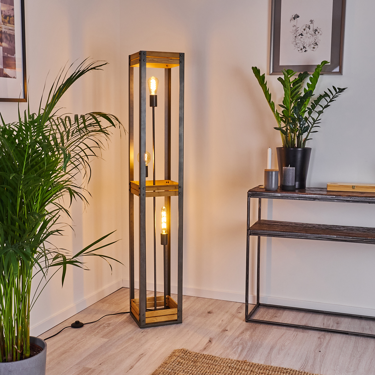 Eine moderne Stehlampe mit rechteckigen Holzrahmen und Glühbirne. Die Lampe steht neben einem Regal und Pflanzen.