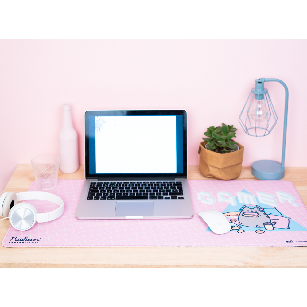 Arbeitsplatz mit Laptop, weißen Kopfhörern und einem pinkfarbenen 'Gamer'-Mousepad mit einer Pusheen-Katze.