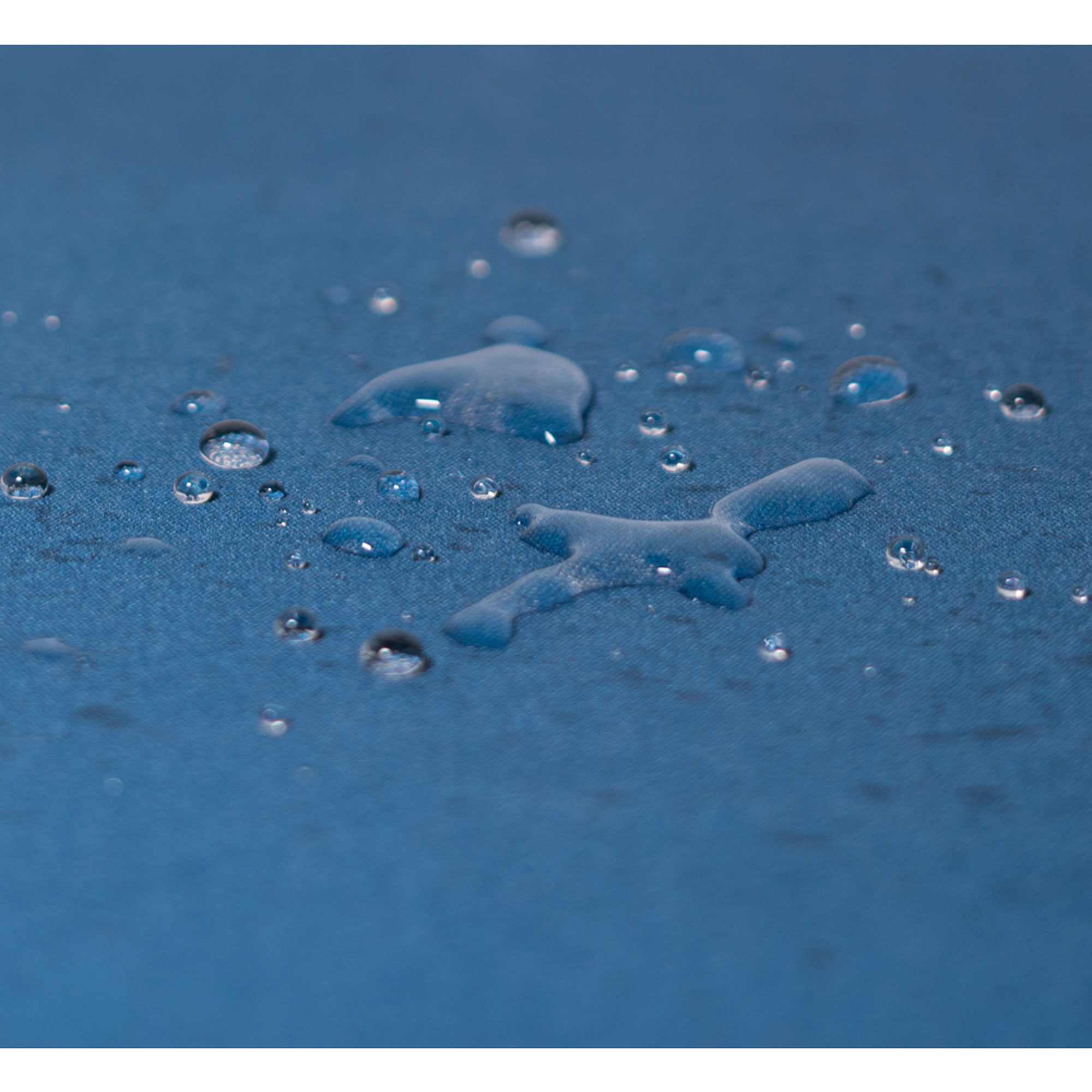 Nahaufnahme von Wassertropfen auf einer blauen Oberfläche. Einige Tropfen sind groß und bilden Formen.