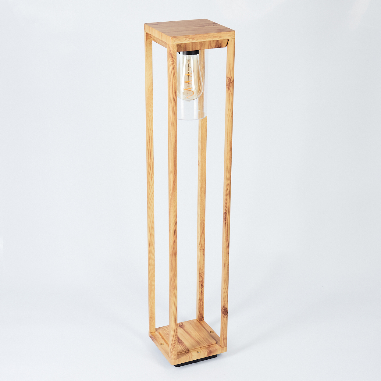 Hohe Holzlampe mit einem Zylinder aus klarem Glas, der eine Glühbirne enthält.