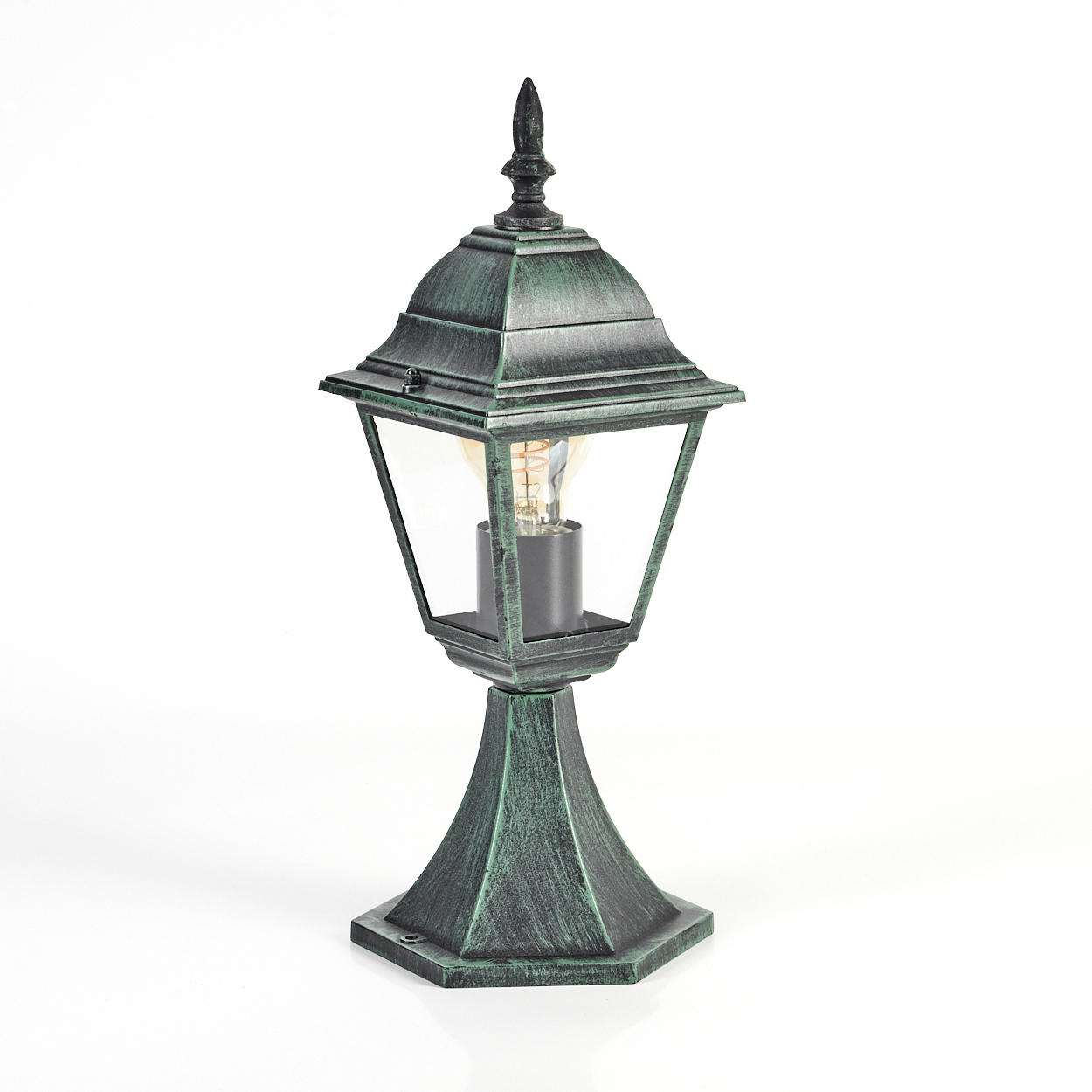 Eine grüne Lampe mit einer Glühbirne. Sie hat ein detailliertes Design und steht auf einer weißen Oberfläche.