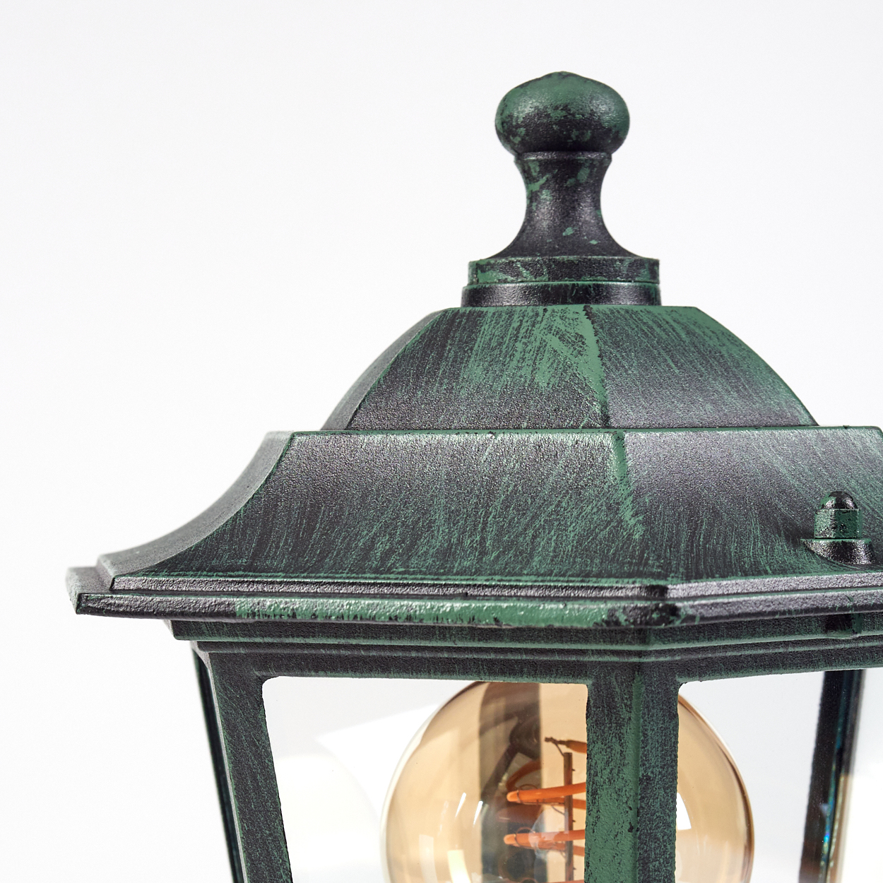 Nahaufnahme der Oberseite einer grünen Außenlampe. Mit Edison-Glühbirne.
