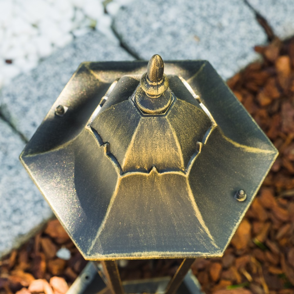 Nahaufnahme der Oberseite einer Bronze-Außenlampe mit Zierknauf.
