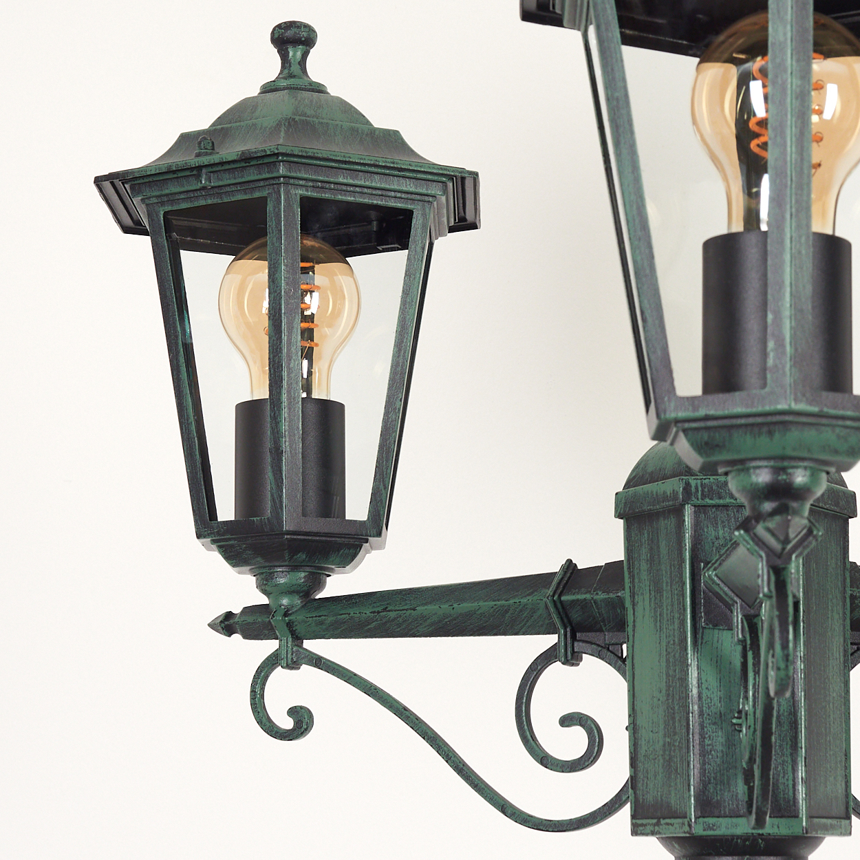 Nahaufnahme einer grünen Laterne mit zwei Lampen. Jede hat ein Glasgehäuse und eine leuchtende Glühbirne.