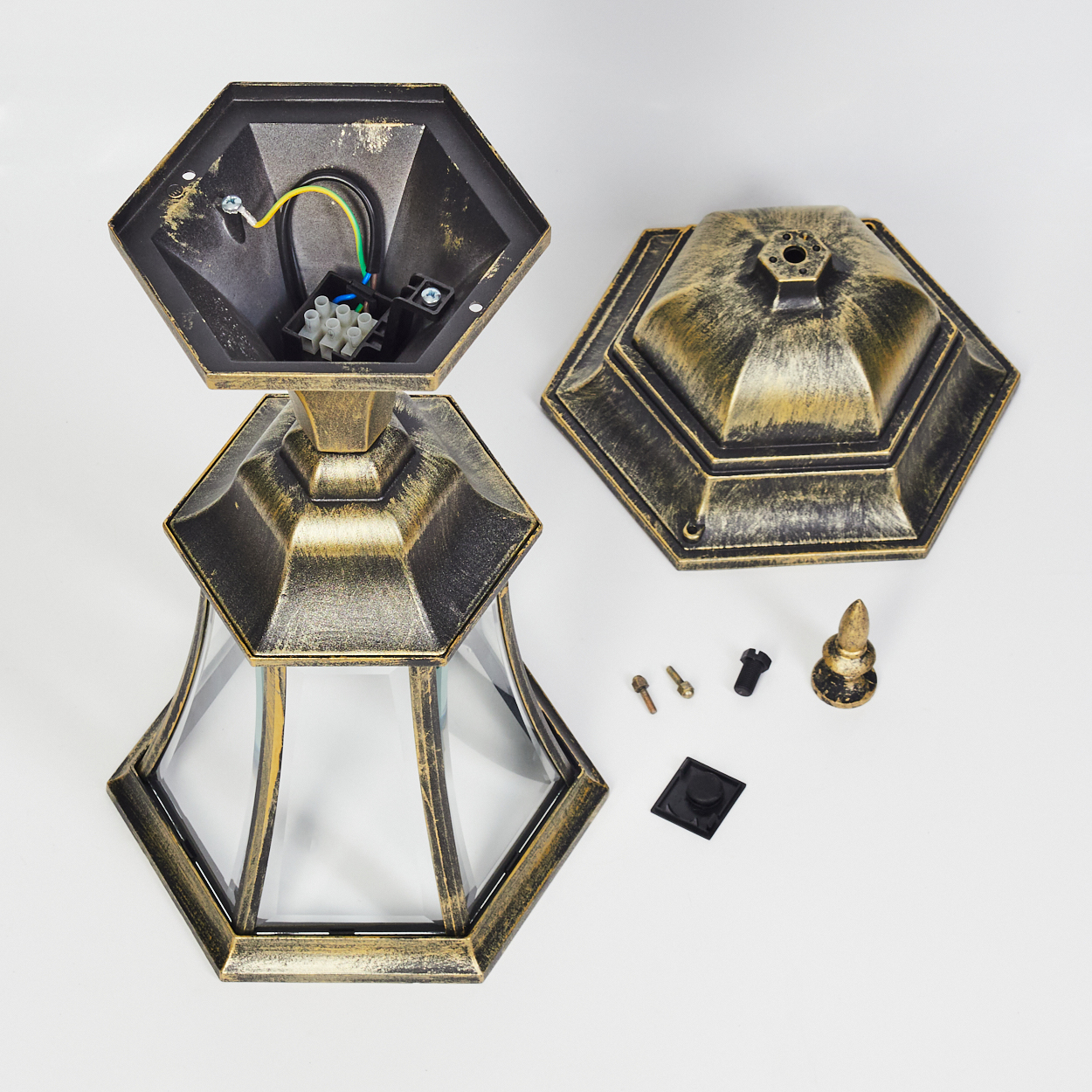 Zerlegte gold-schwarze Außenlampe. Teile umfassen Oberteil, Sockel, Glasscheiben, Schrauben und Zieraufsatz.