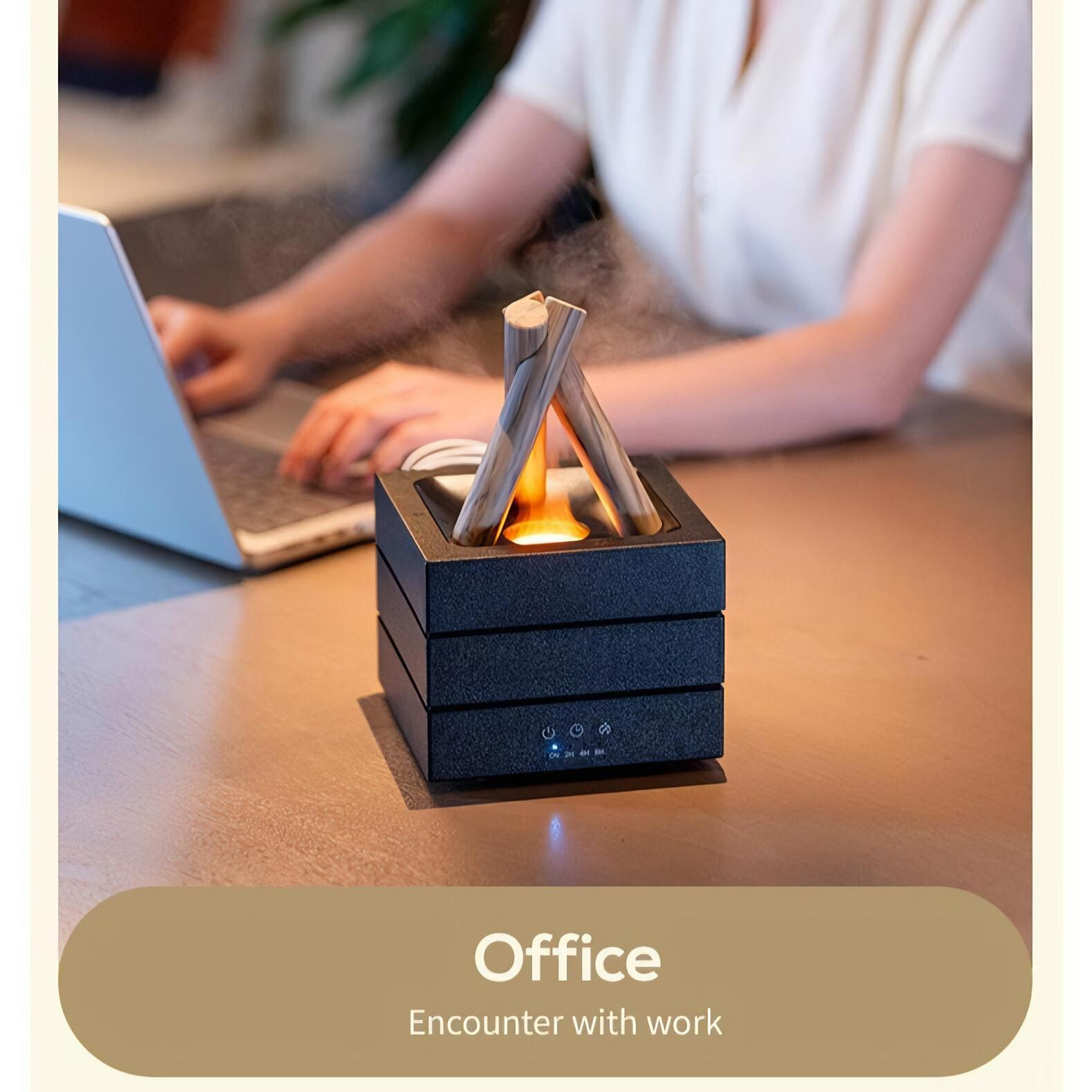 Ein schwarzes Deko-Objekt mit Lichtquelle, auf einem Holztisch platziert. Eine Person arbeitet mit einem Laptop.
