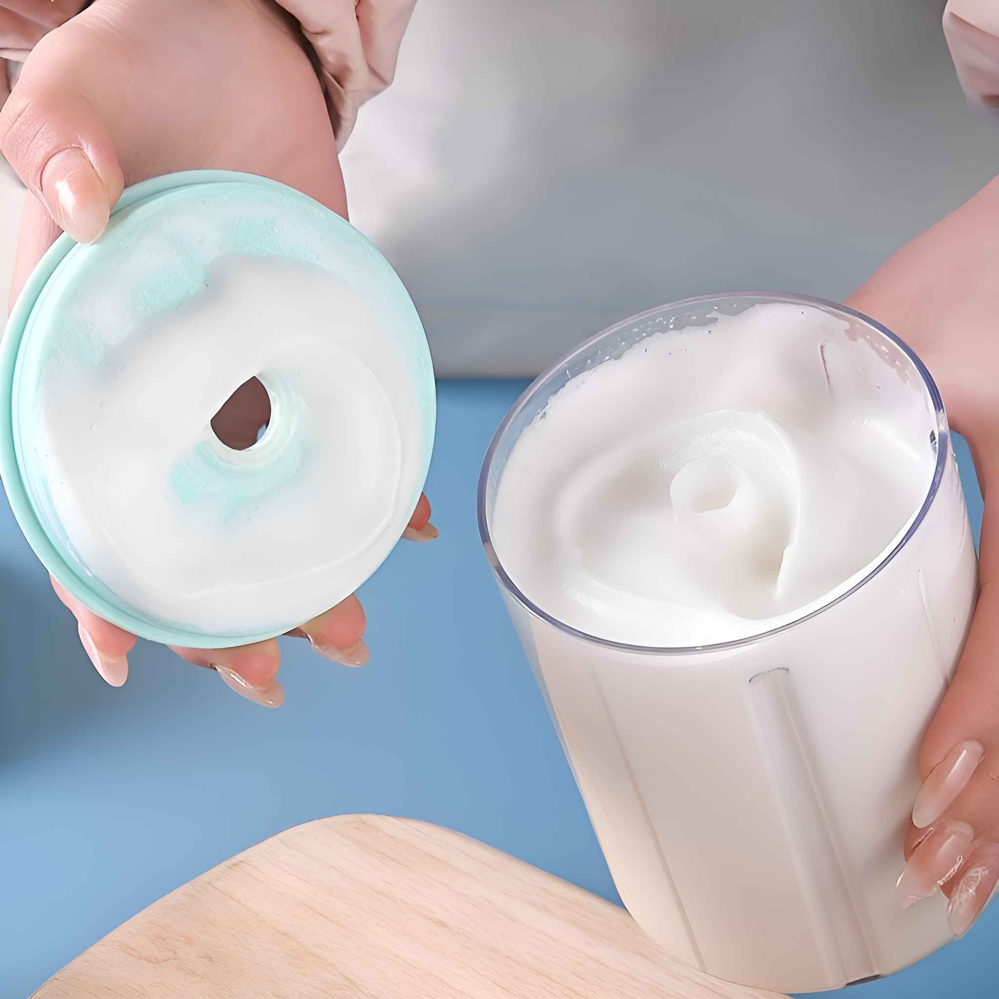 Hände halten einen Behälter mit weißem Schaum und einem blau-grünen Deckel.