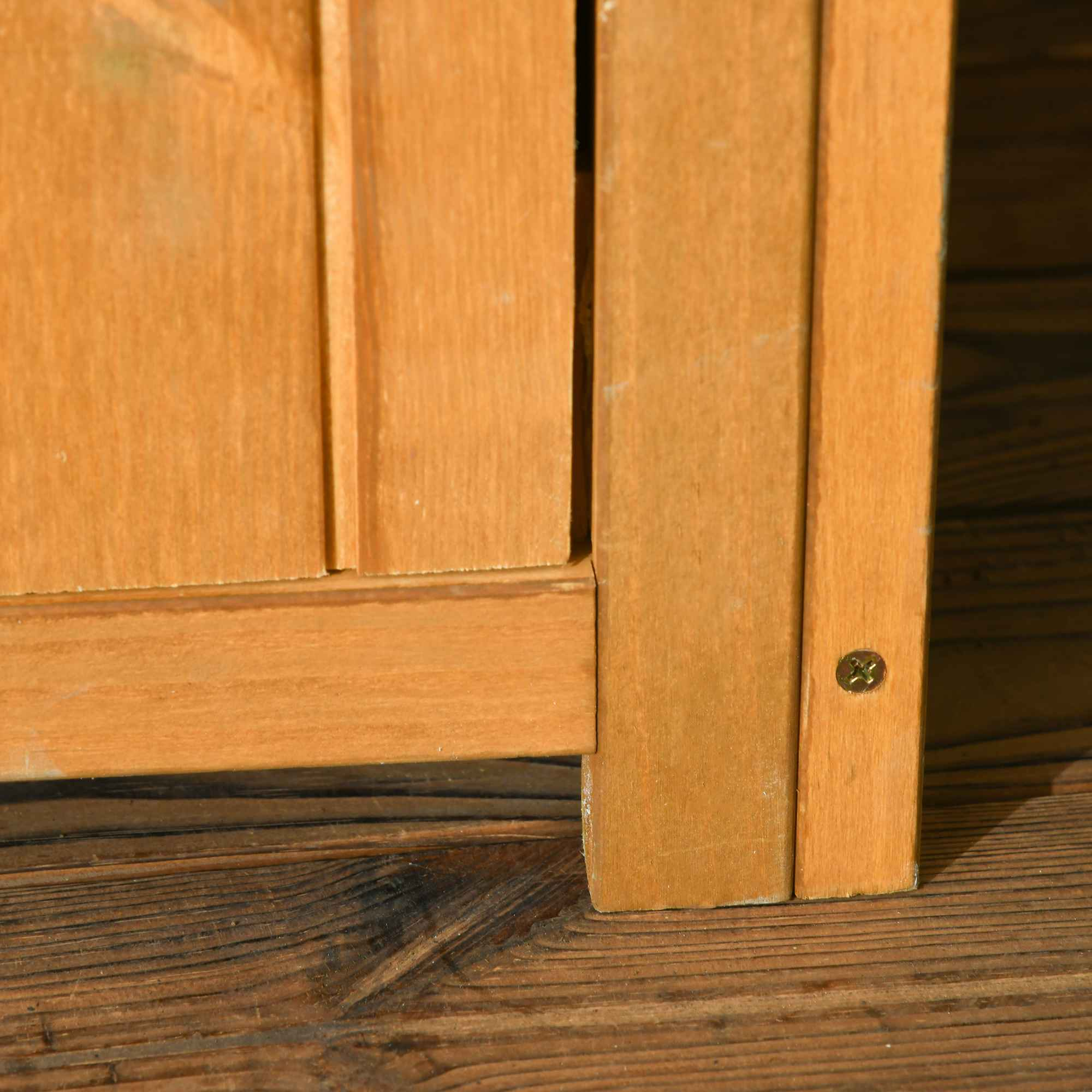 Nahaufnahme einer Holzkastenecke. Das Holz ist hellbraun und die Ecke hat eine Messingschraube.