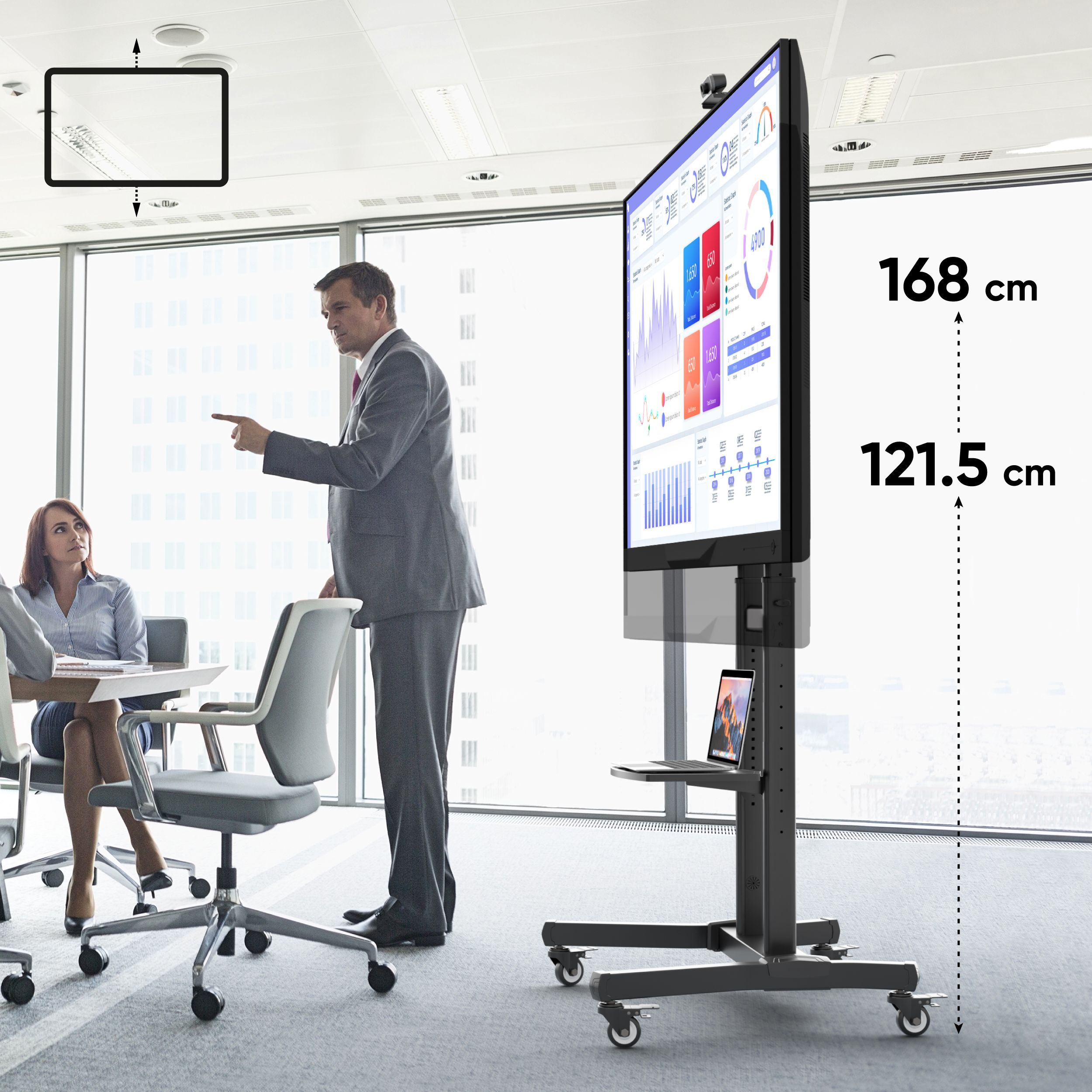 Spotkanie biznesowe w sali konferencyjnej. Mężczyzna wskazuje na duży telewizor.