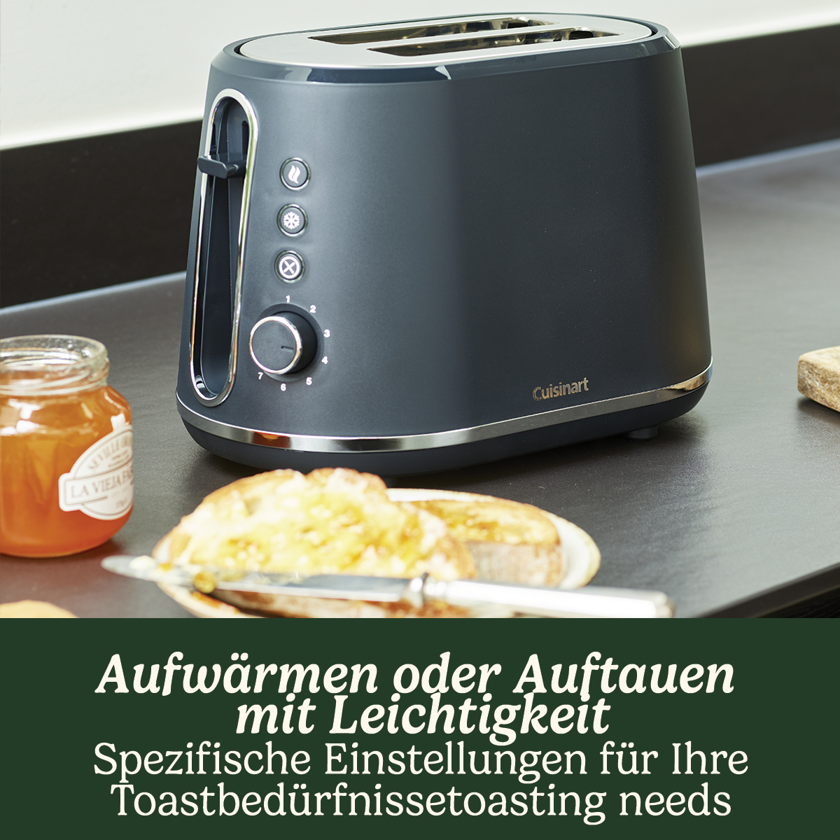 Donkergrijze broodrooster met twee sneetjes toast op een aanrecht. Tekst is inbegrepen.