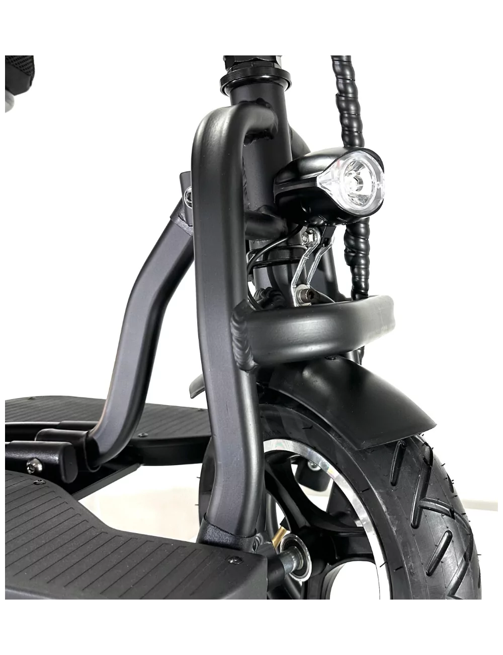 Primer plano del faro y el neumático delantero de un scooter de movilidad negro.