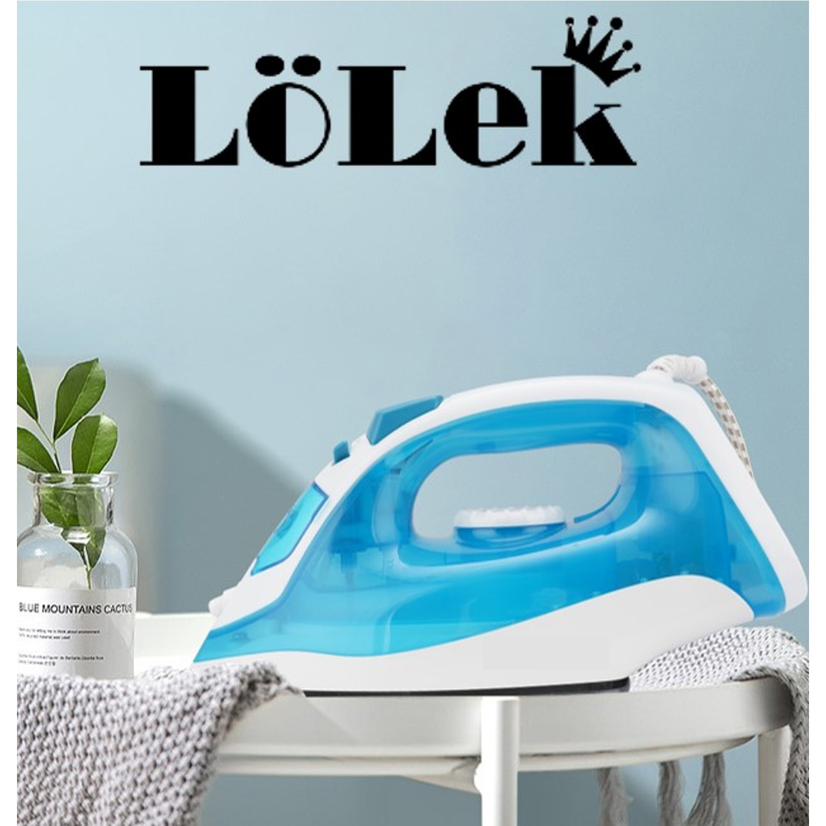 Una plancha azul y blanca sobre una mesa con una planta y un paño gris. La marca LöLek está escrita arriba.