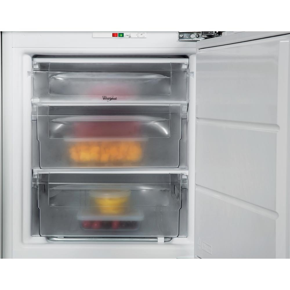 Primer plano de un congelador con cajones abiertos. Tres cajones transparentes con alimentos. Logotipo de Whirlpool.