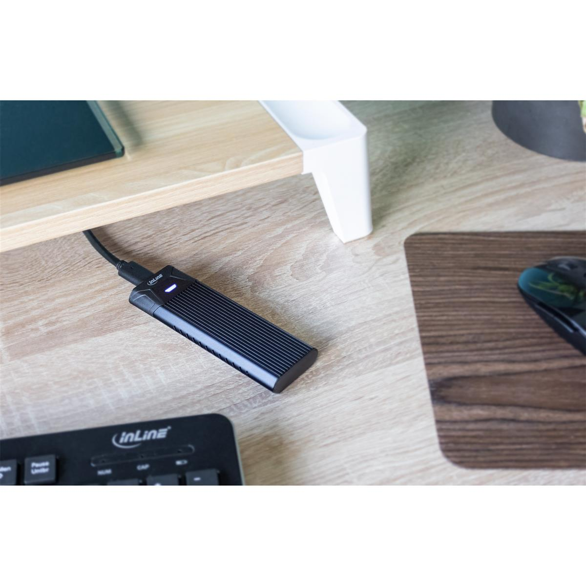 Czarny dysk twardy jest podłączony do laptopa na drewnianym biurku.