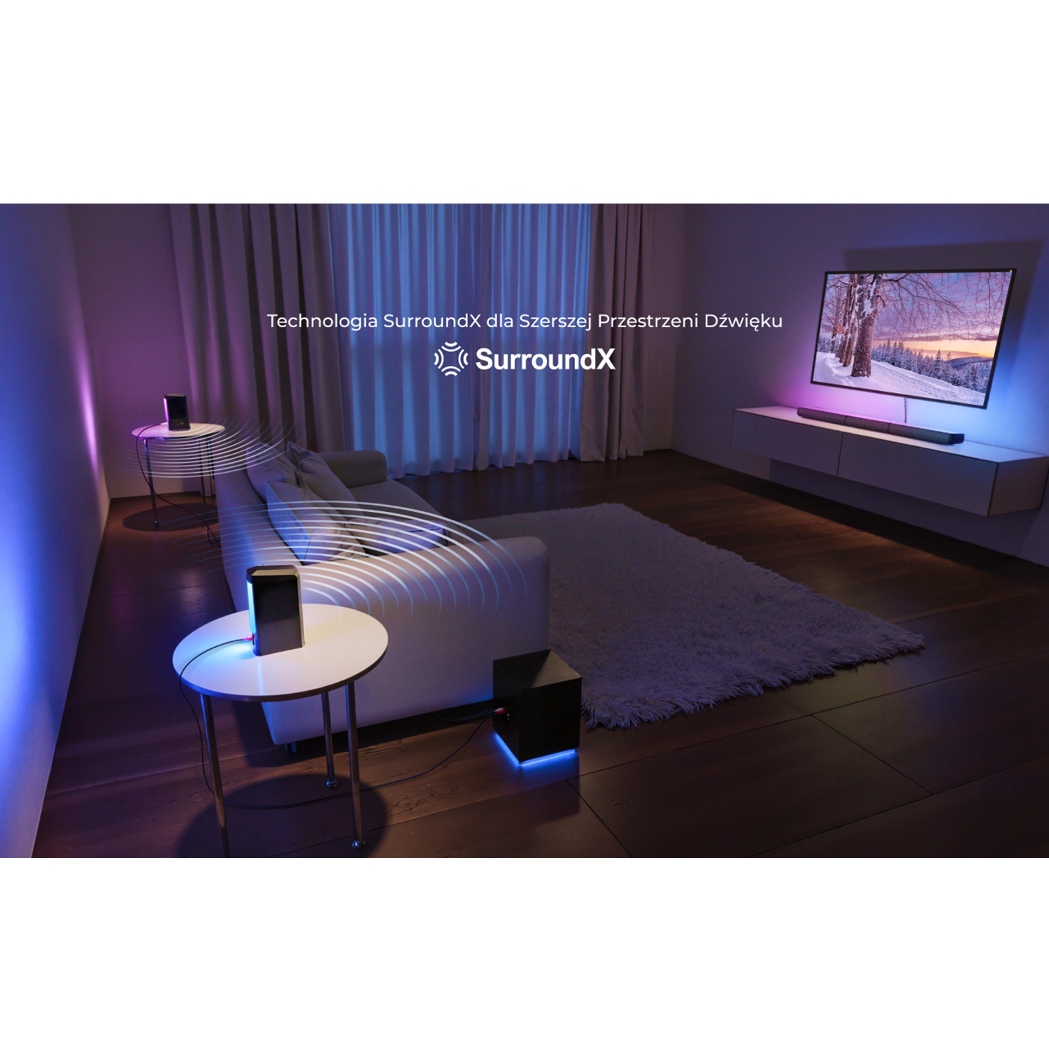 Salon z kanapą, telewizorem i głośnikami. Telewizor jest włączony. Głośniki stoją na stojakach.