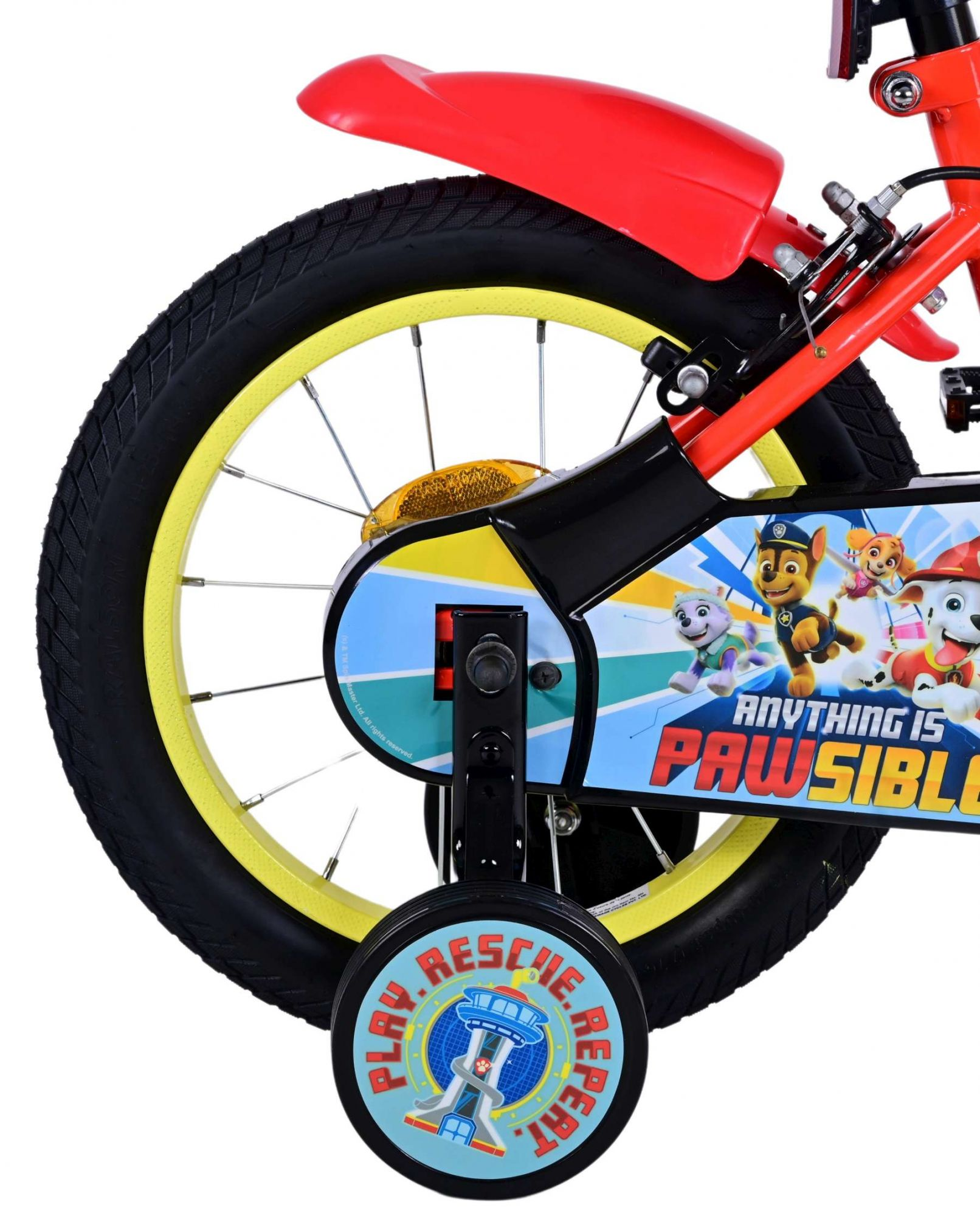 Nahaufnahme eines rot-gelben Kinderfahrradrads mit Paw Patrol-Design an der Seite und Stützrädern.