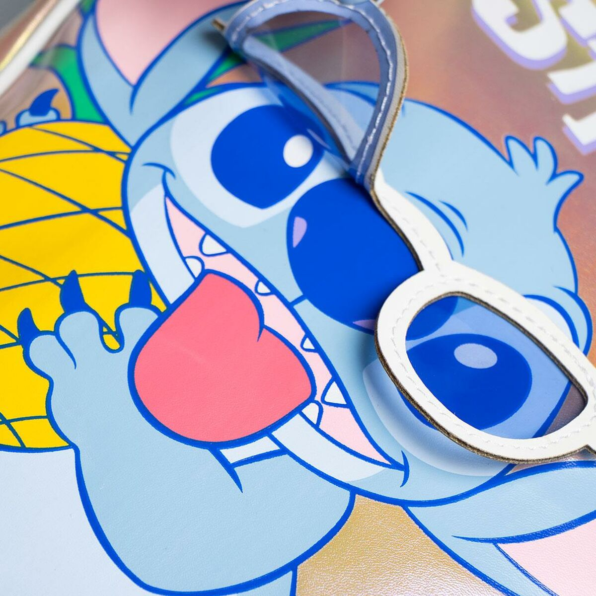 Nahaufnahme einer Stitch-Figur mit Sonnenbrille. Das Bild ist auf einer glänzenden Oberfläche mit farbenfrohem Hintergrund.
