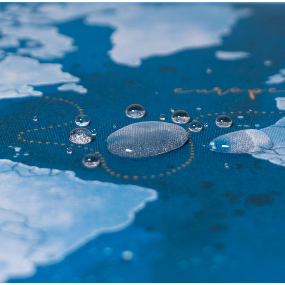 Wassertropfen auf einer blauen Oberfläche mit Kartenmotiv. Die Karte zeigt einen Teil von Europa.