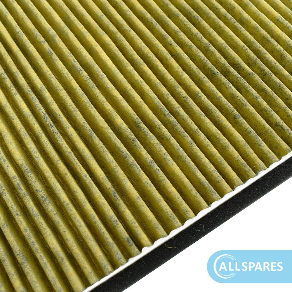 Primo piano di un filtro giallo a pieghe. Le pieghe sono verticali. Il filtro è bordato di nero e bianco.