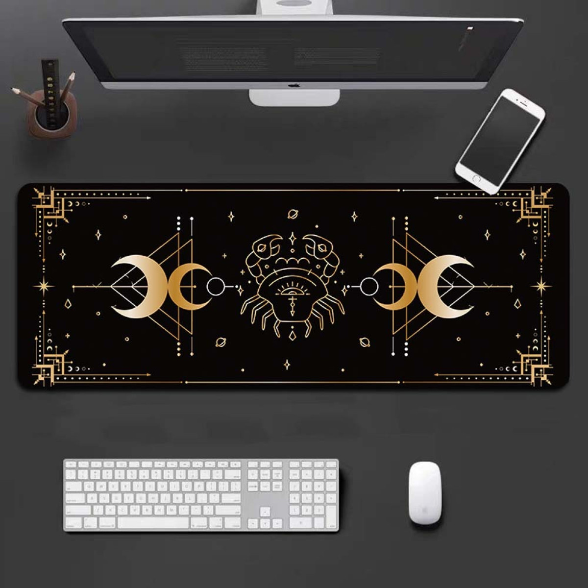 Tappetino da scrivania nero con un design zodiacale, una tastiera, un mouse, un monitor e un telefono.