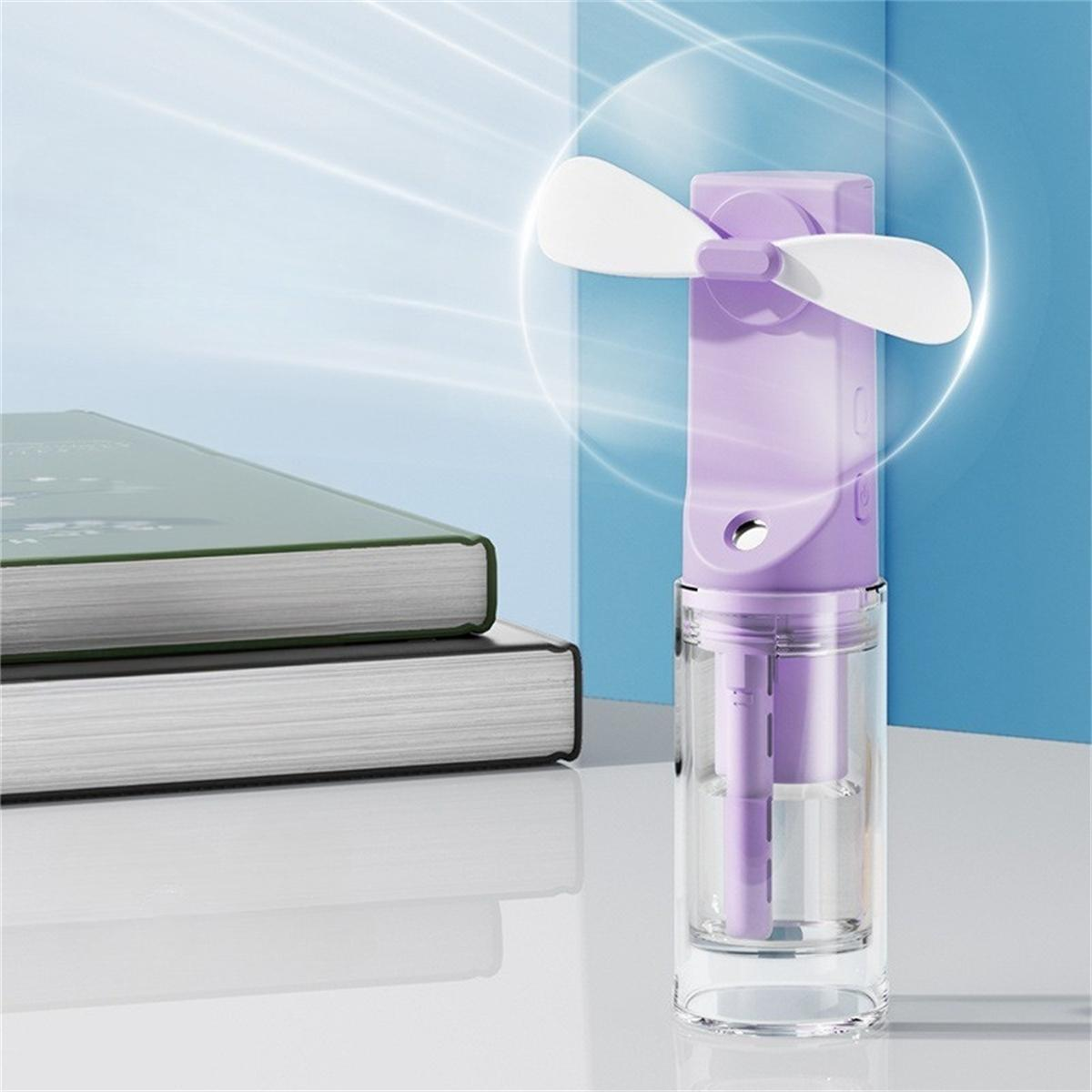 Ein lila Mini-Tragbarer Ventilator mit einem klaren Wassertank und Büchern auf einem weißen Tisch.