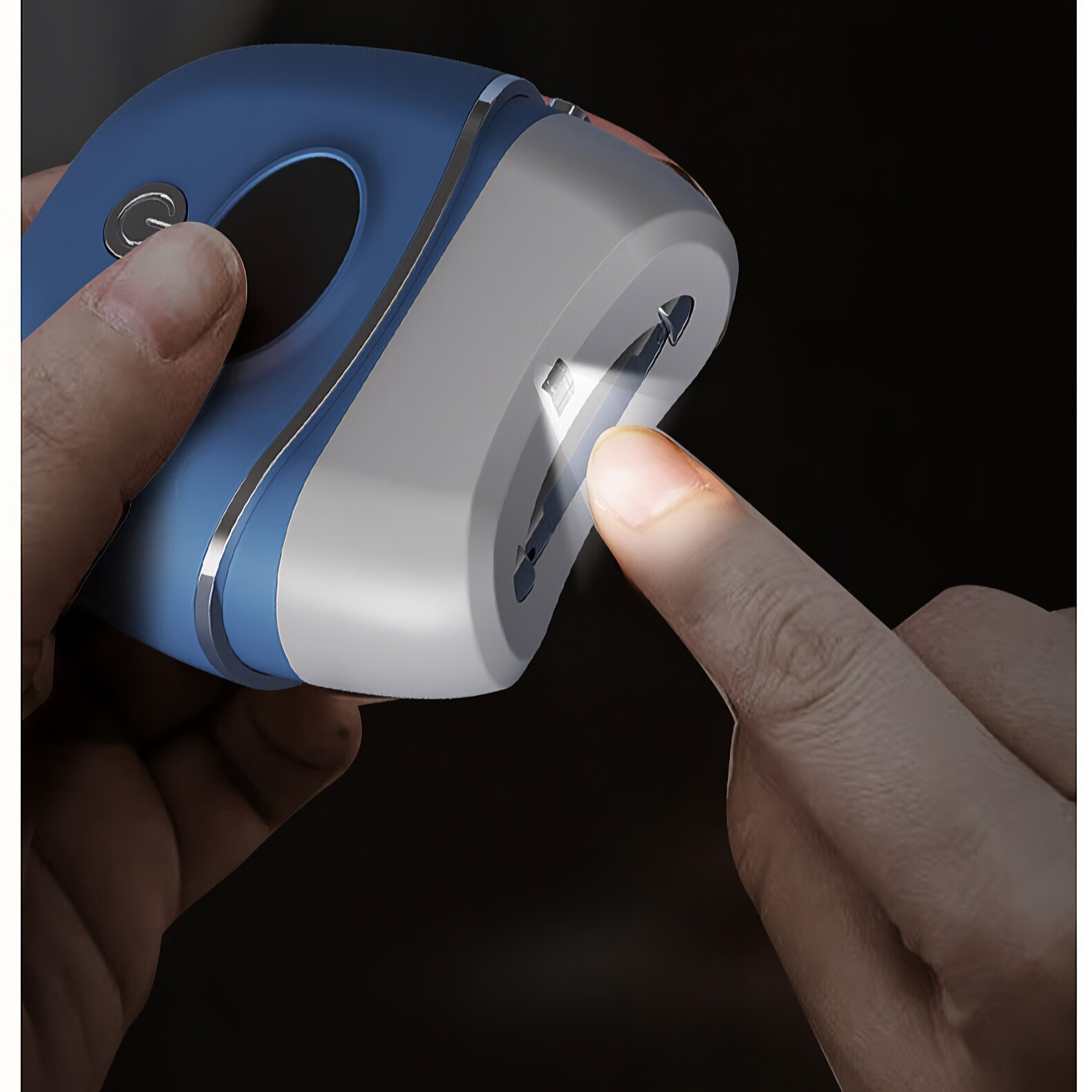 Eine Hand berührt ein blaues Gerät mit einem Licht, das auf dunklem Hintergrund scheint.