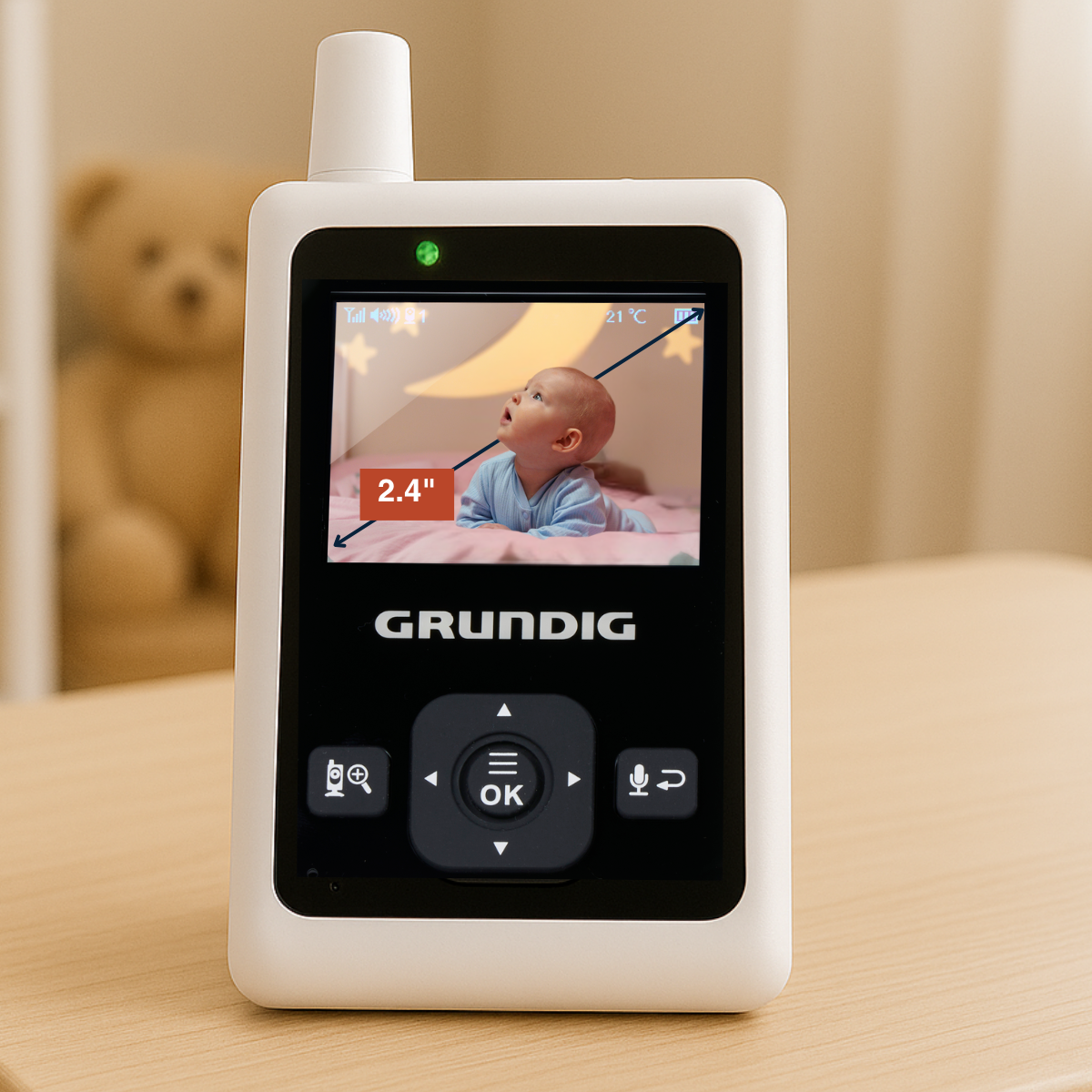 A baby monitor with a screen displaying a baby. The monitor is branded GRUNDIG.