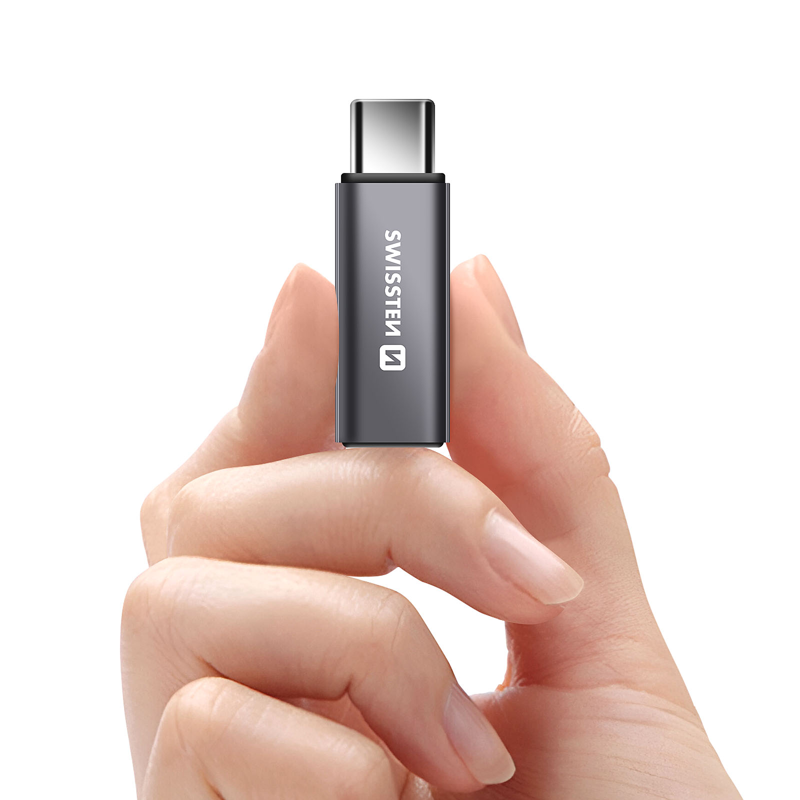 Une main tenant un adaptateur USB-C vers USB-C. L'adaptateur est gris avec le logo Swissten.